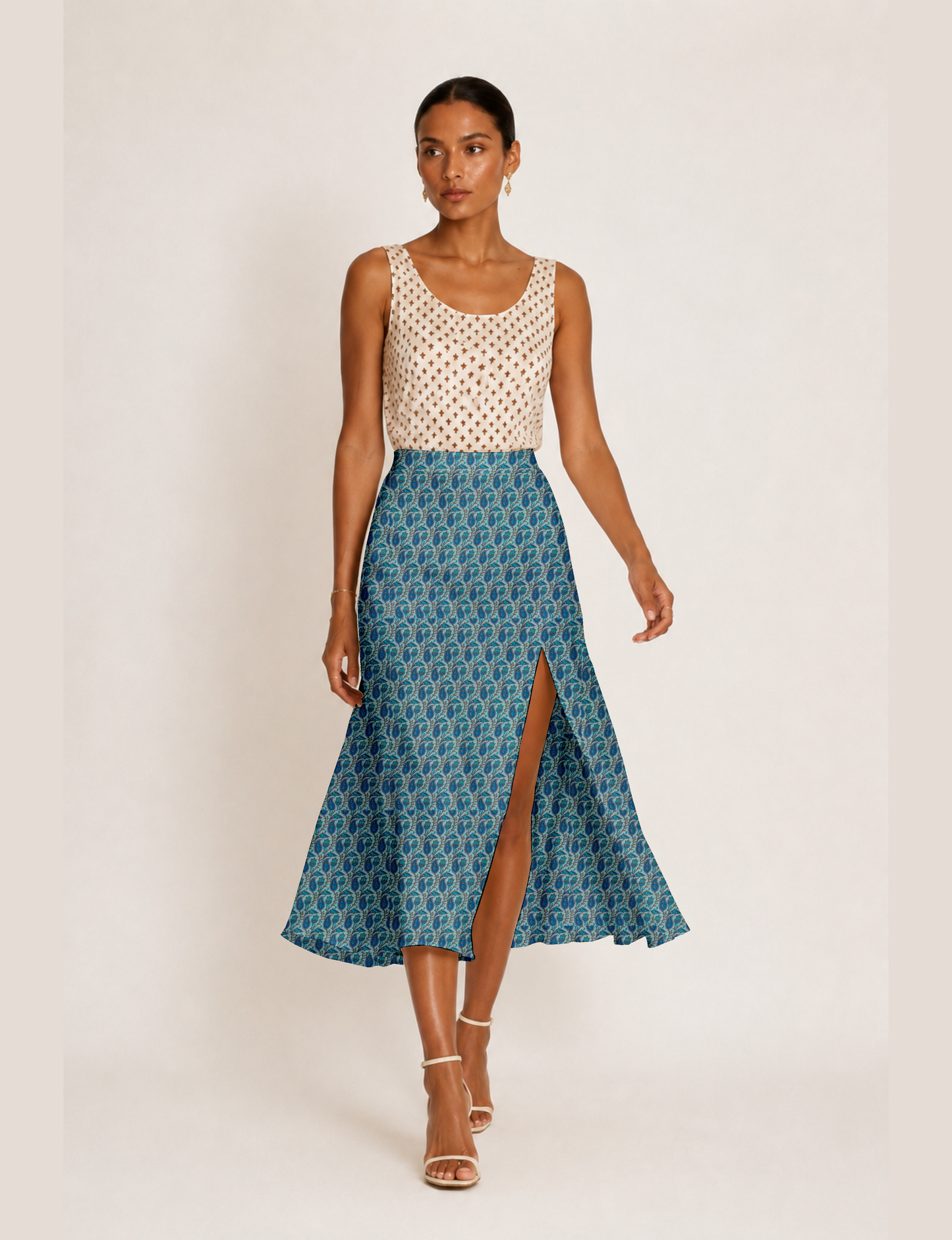 Woman wearing a yellow and black micro patterned A-line skirt with front slit, paired with beige sleeveless top and black