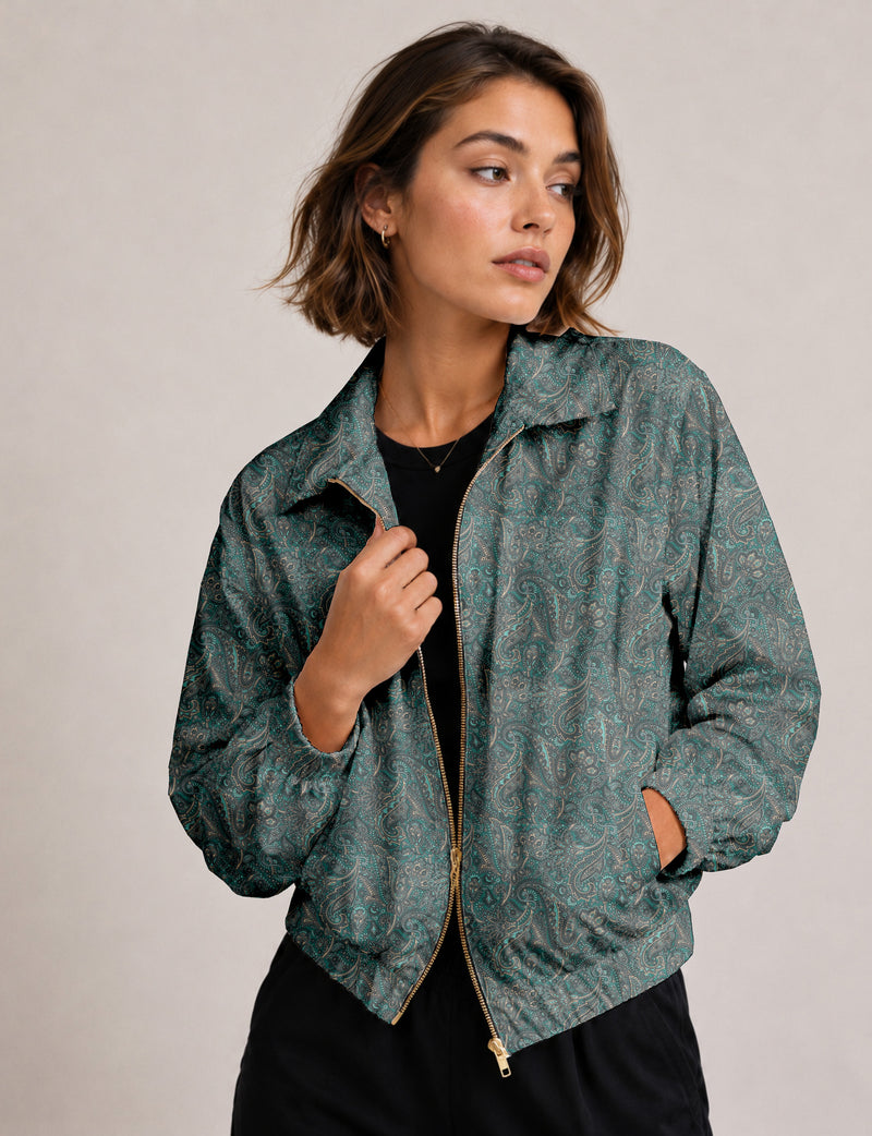 Woman wearing a yellow floral bomber jacket with front zipper, elastic cuffs, and side pockets, shown from front view