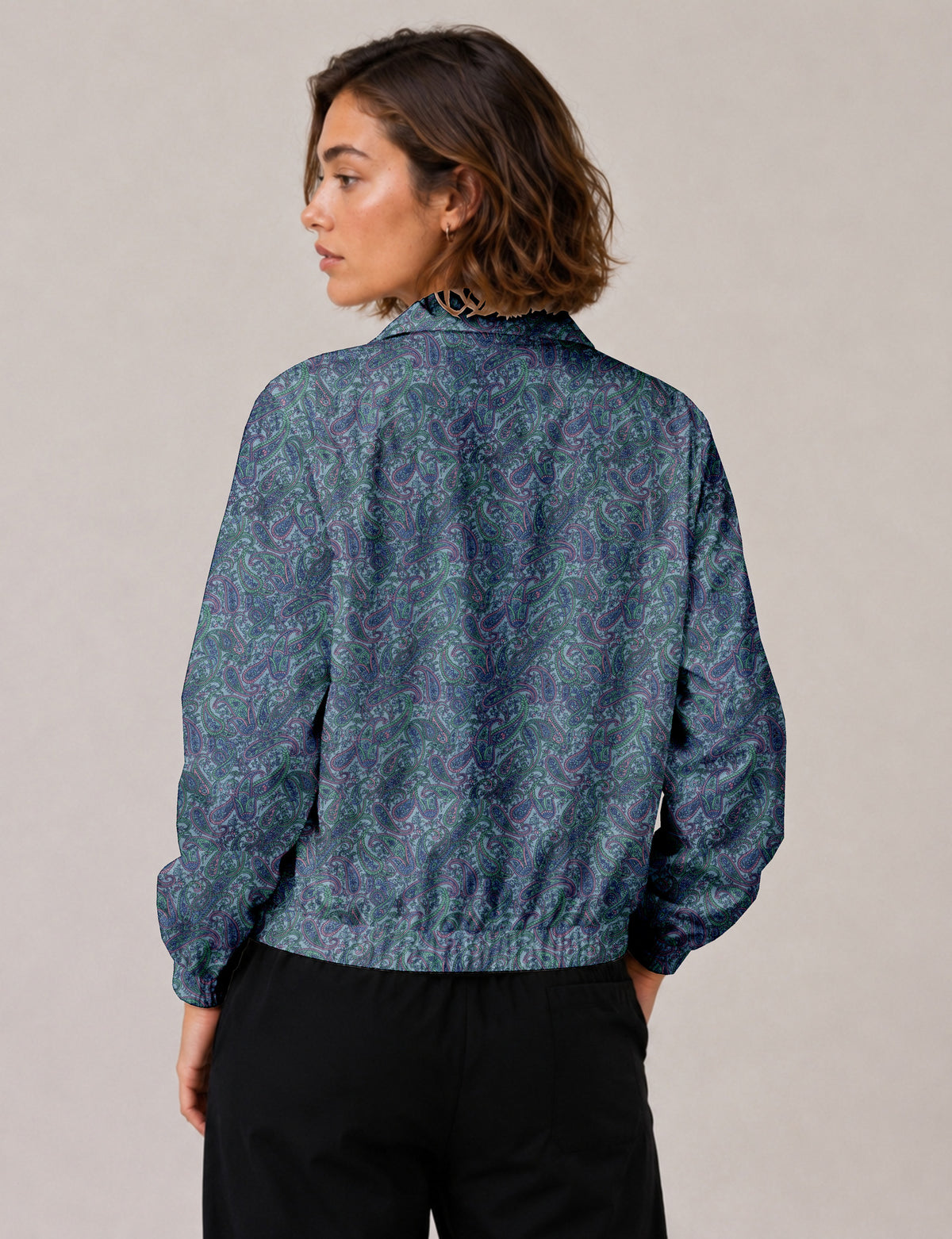 Brown floral bomber jacket with front zipper, elastic cuffs and hem, hanging on white hanger, red floral inner lining visible