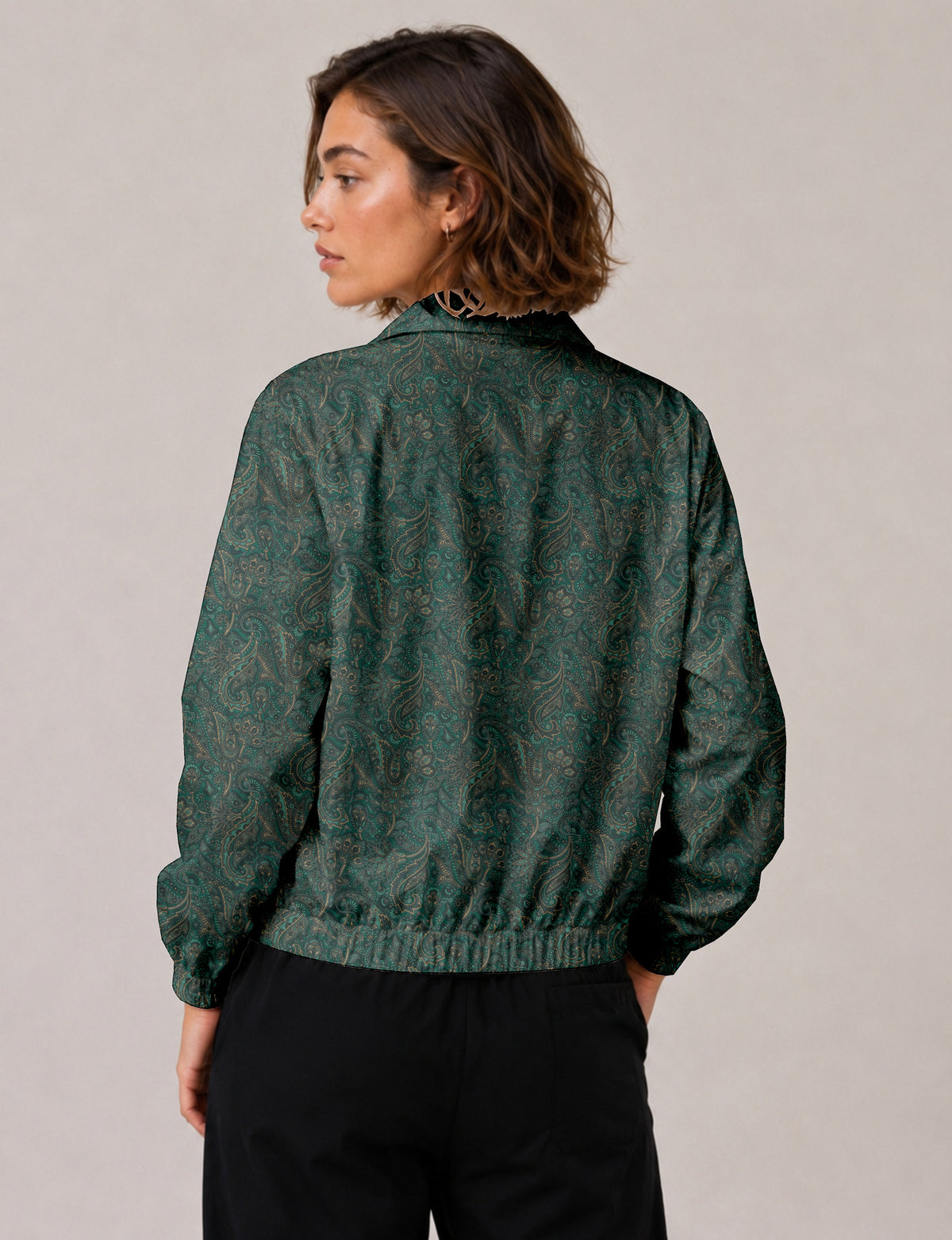 Woman wearing a yellow floral bomber jacket with front zipper, elastic cuffs, and side pockets, shown from front view