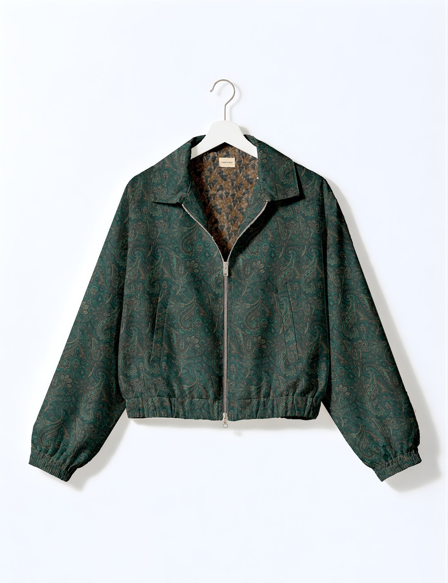 Brown floral bomber jacket with front zipper, elastic cuffs and hem, hanging on white hanger, red floral inner lining visible