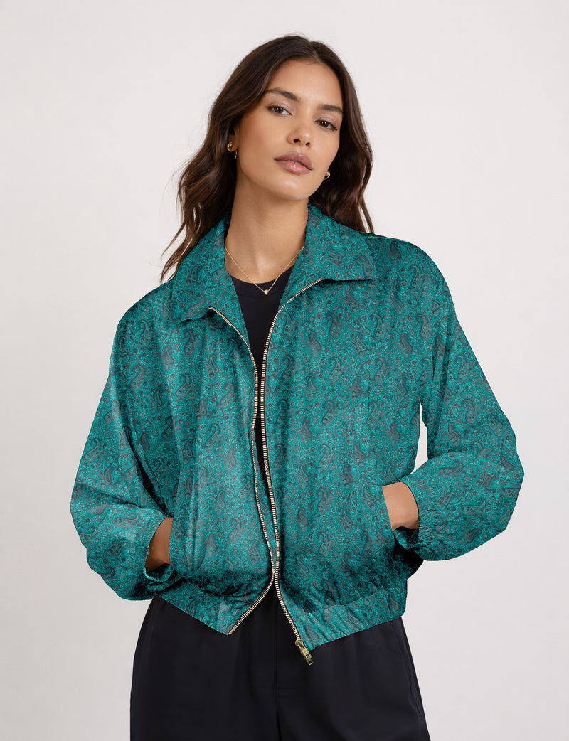 Woman wearing a yellow floral bomber jacket with front zipper, elastic cuffs, and side pockets, shown from front view