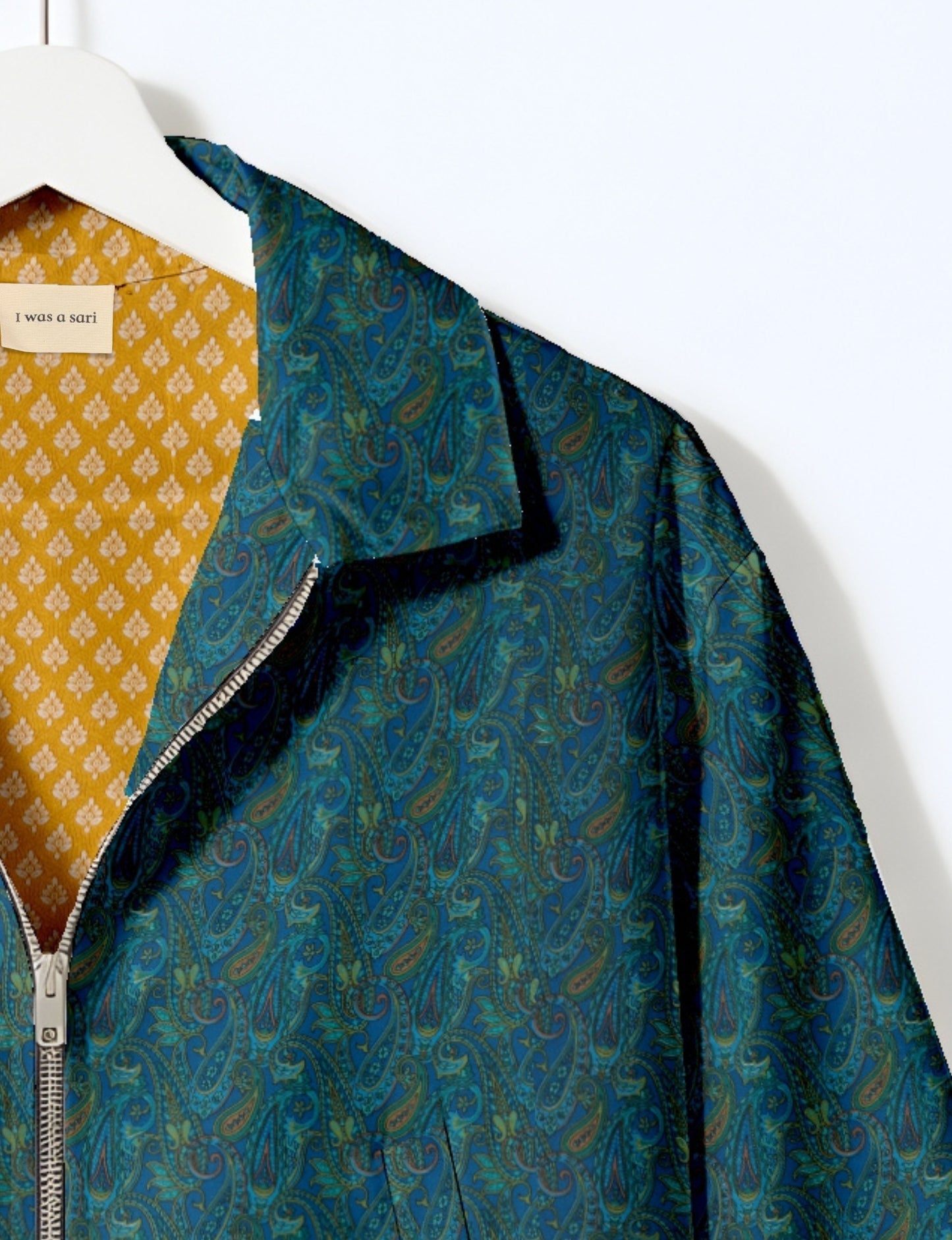 Woman wearing a yellow bomber jacket with a micro geometric pattern, front zipper, and side pockets, paired with black pants