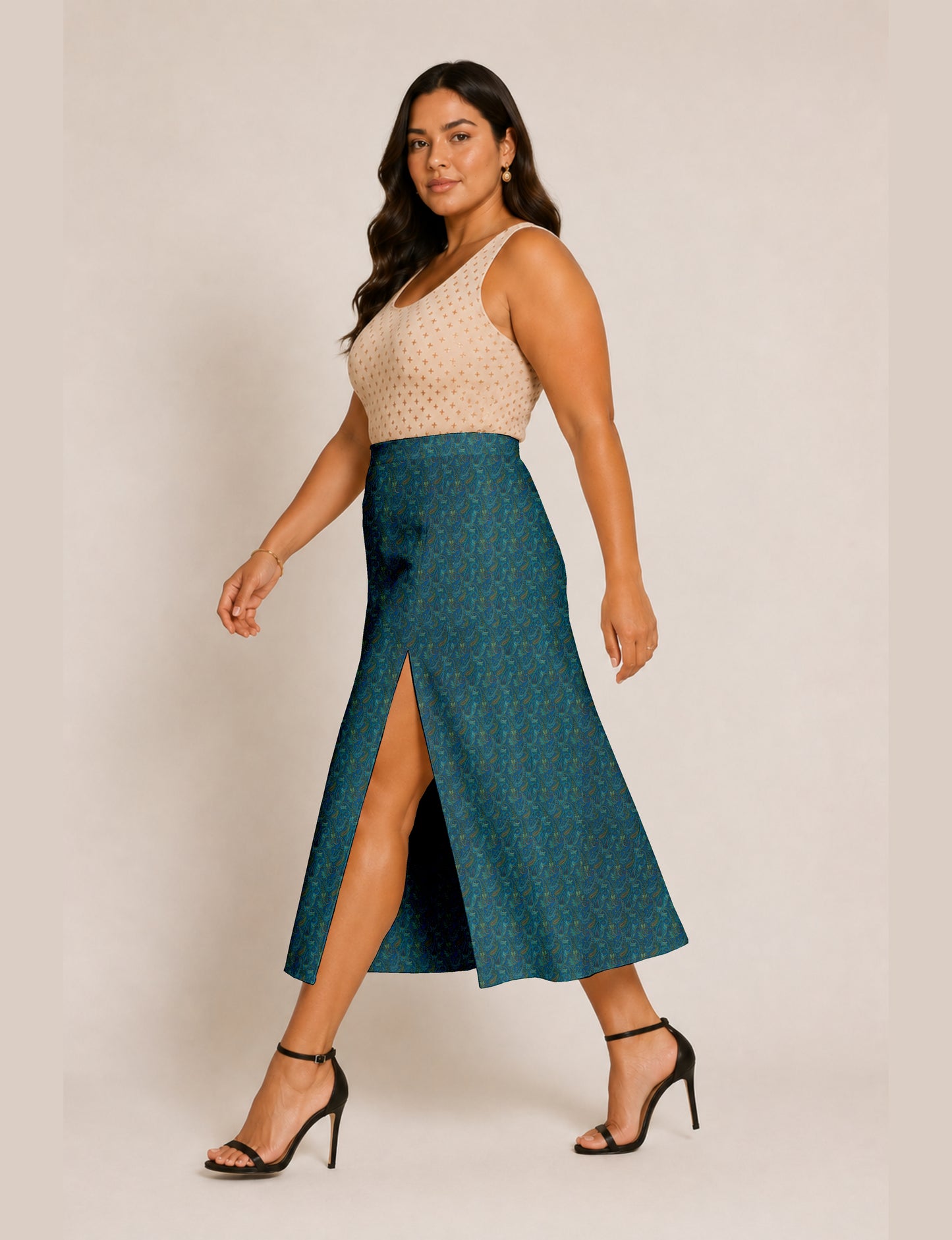 Woman wearing a yellow and black micro patterned A-line skirt with front slit, paired with beige sleeveless top and black