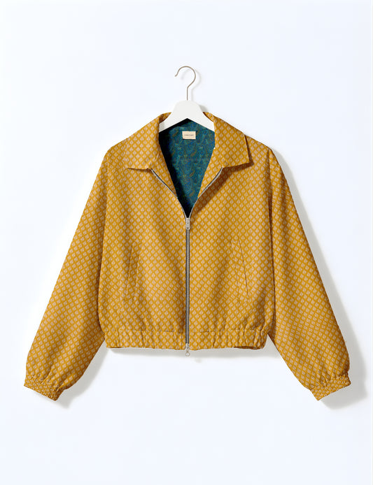 Yellow bomber jacket with micro geometric pattern, silver front zipper, elastic cuffs, and blue floral inner lining, hanging