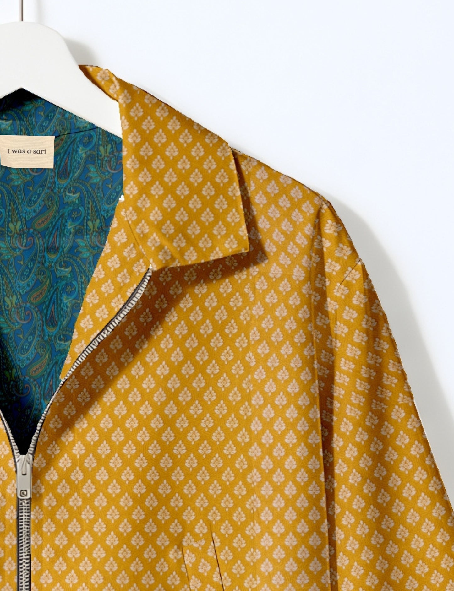 Woman wearing a yellow bomber jacket with a micro geometric pattern, front zipper, and side pockets, paired with black pants