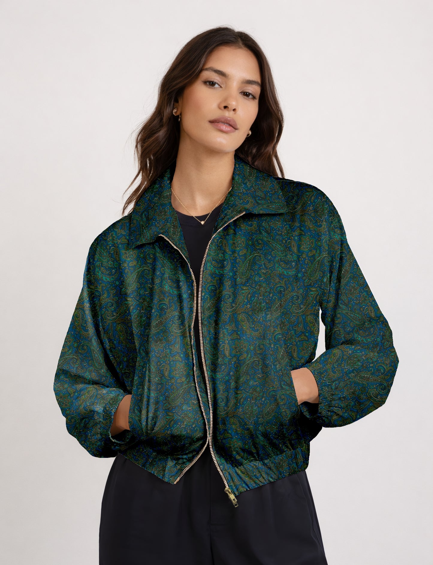Woman wearing a yellow bomber jacket with a micro geometric pattern, front zipper, and side pockets, paired with black pants