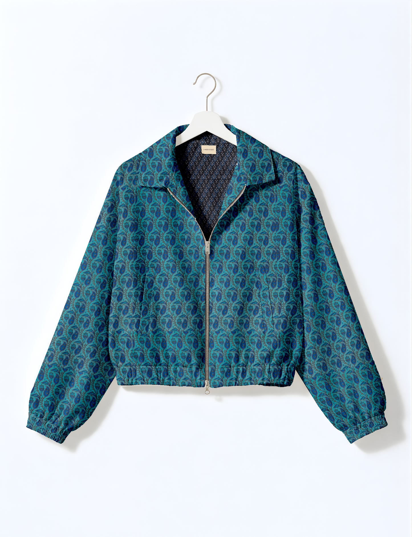 Women's cropped bomber jacket with twin metallic front zippers, welt pockets, elasticated hem and cuffs, and contrast sari print lining.