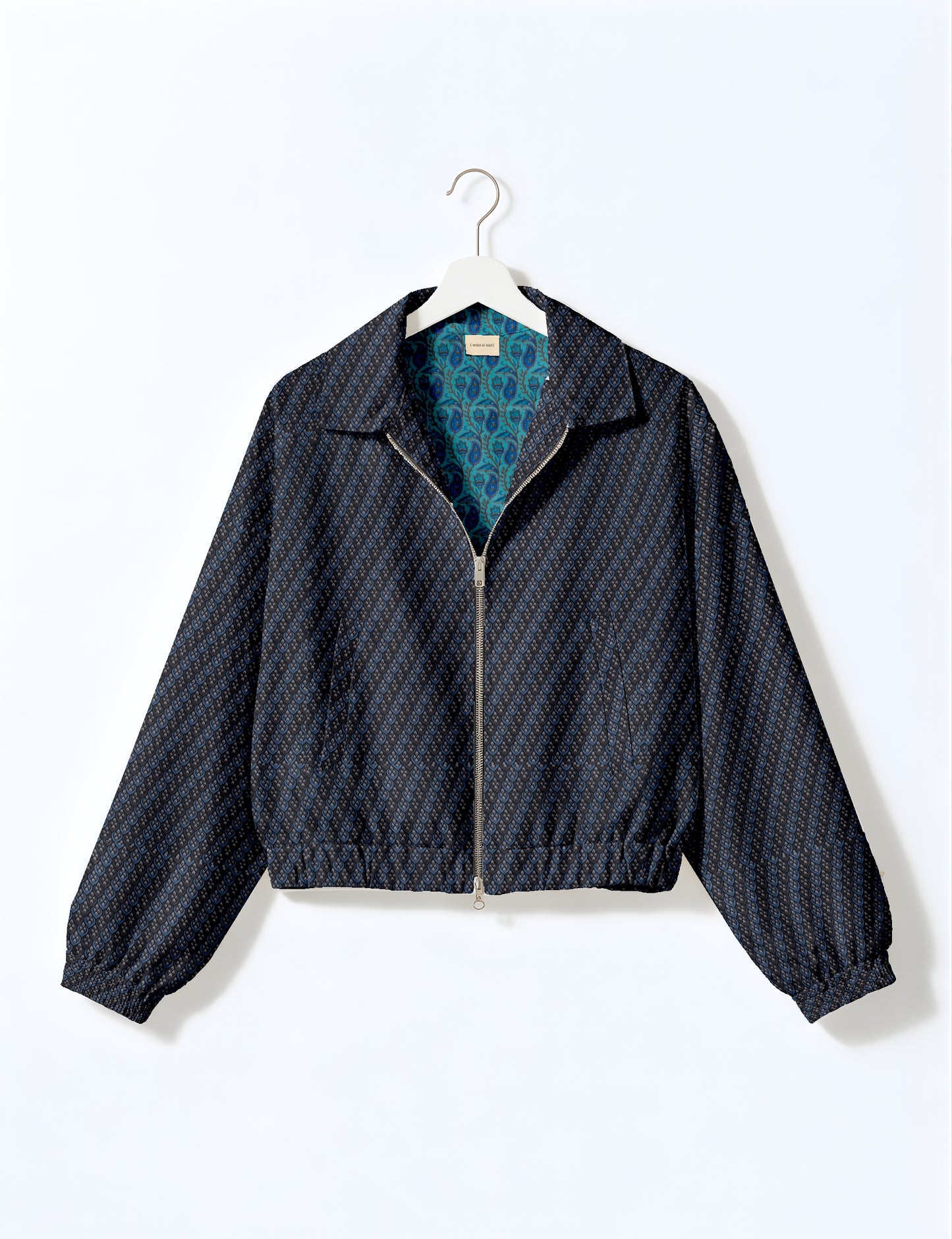 Women's cropped bomber jacket with twin metallic front zippers, welt pockets, elasticated hem and cuffs, and contrast sari print lining.