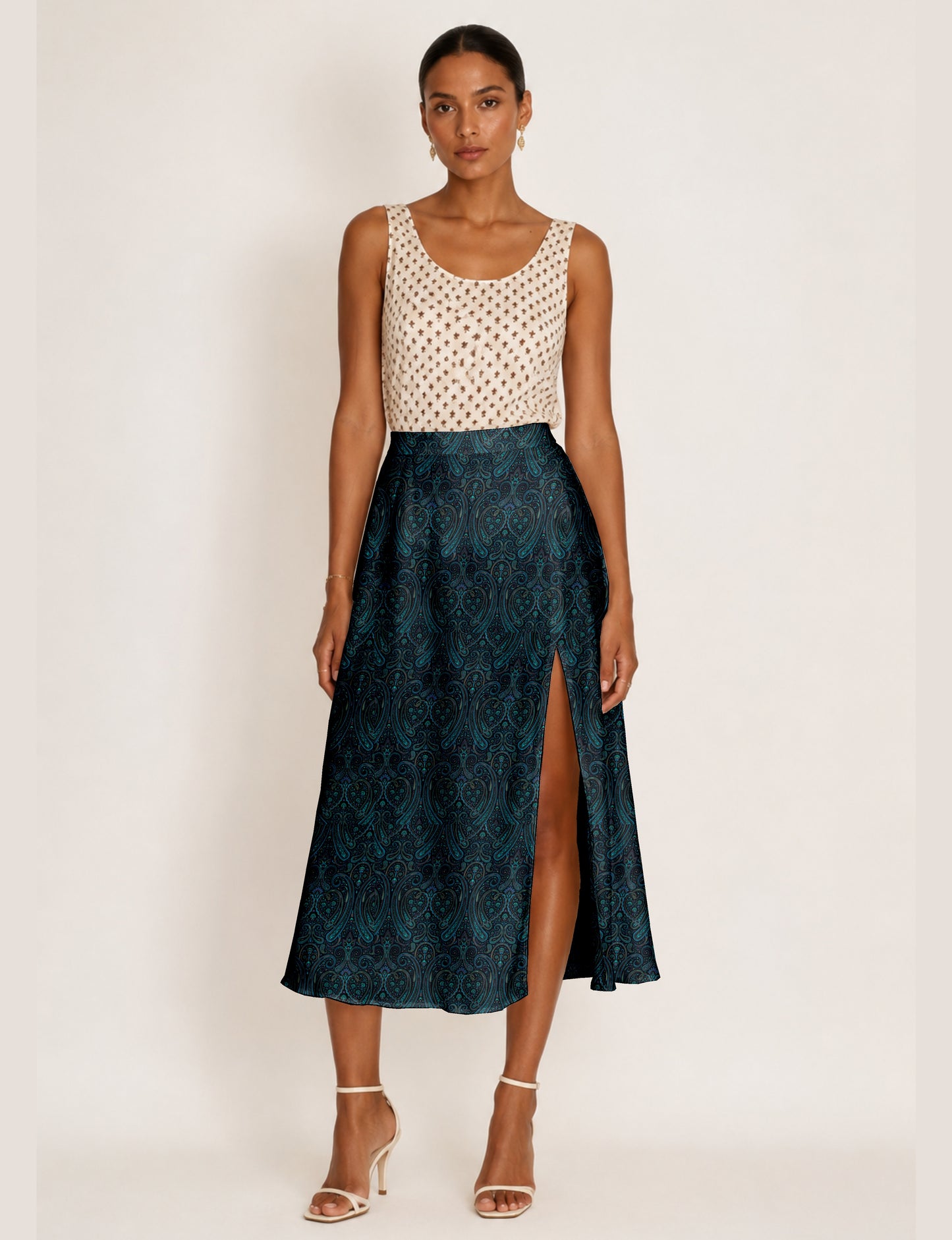 Woman wearing a yellow and black micro patterned A-line skirt with front slit, paired with beige sleeveless top and black