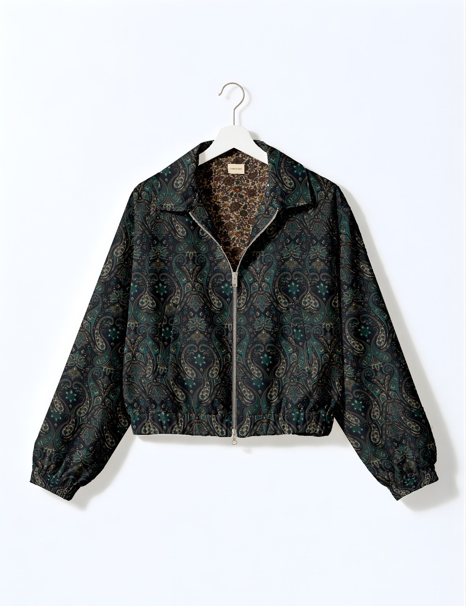 Brown floral bomber jacket with front zipper, elastic cuffs and hem, hanging on white hanger, red floral inner lining visible