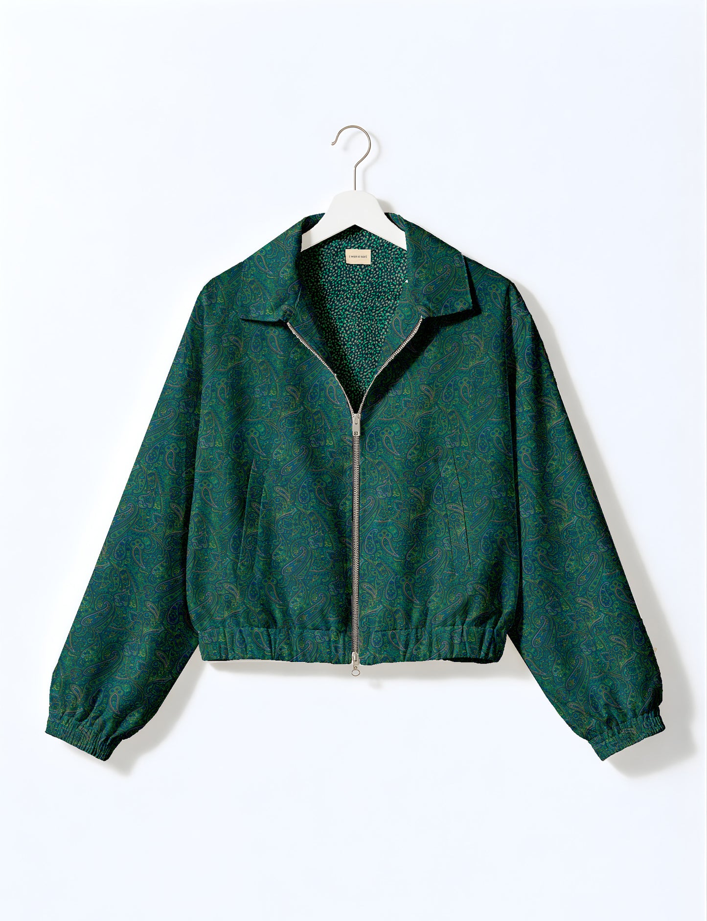 Women's cropped bomber jacket with twin metallic front zippers, welt pockets, elasticated hem and cuffs, and contrast sari print lining.