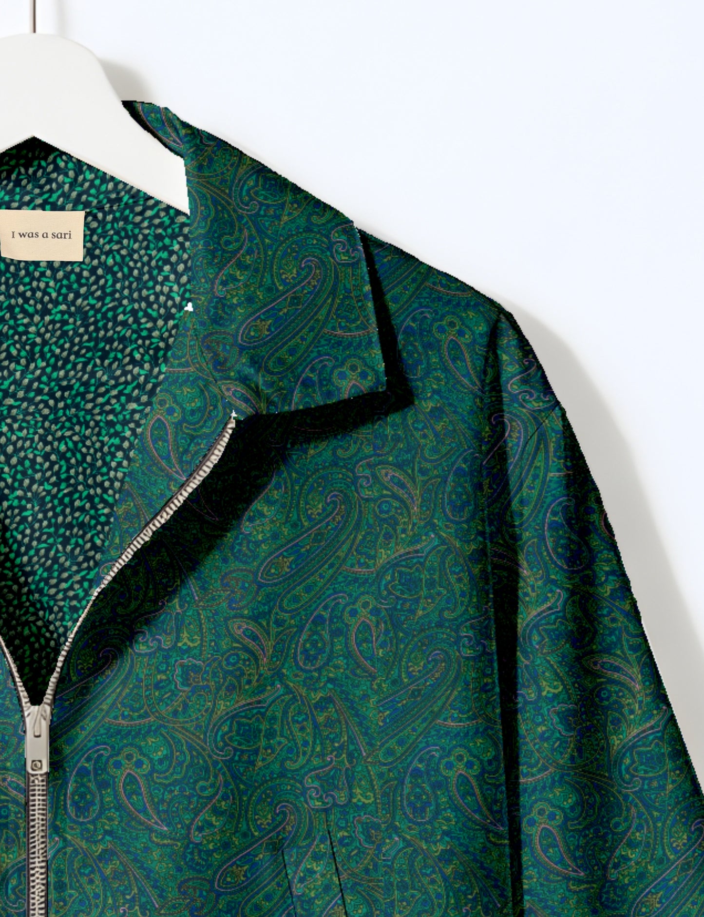 Women's cropped bomber jacket with twin metallic front zippers, welt pockets, elasticated hem and cuffs, and contrast sari print lining.