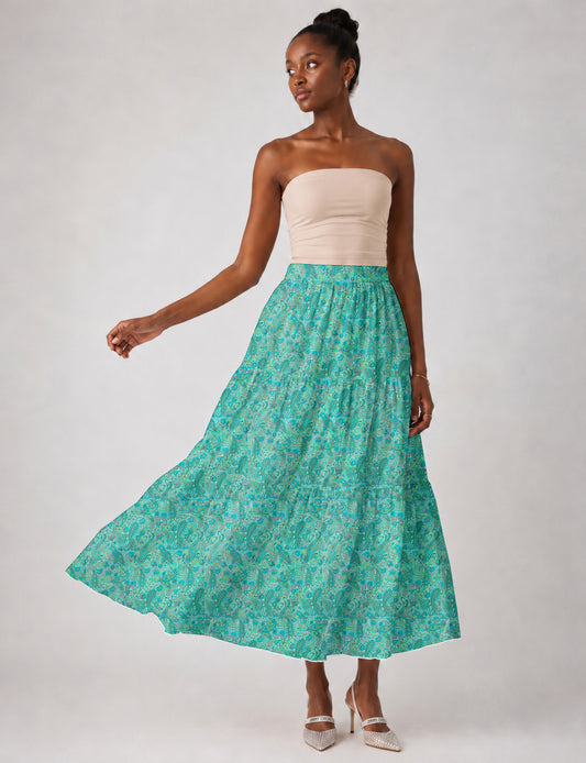 Woman wearing a yellow midi tiered skirt with a small geometric pattern, paired with a beige strapless top and white heels
