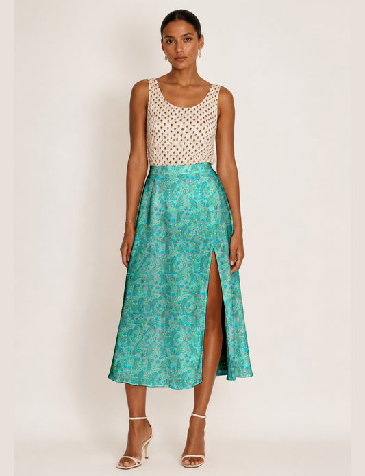 Woman wearing a yellow and black micro patterned A-line skirt with front slit, paired with beige sleeveless top and black