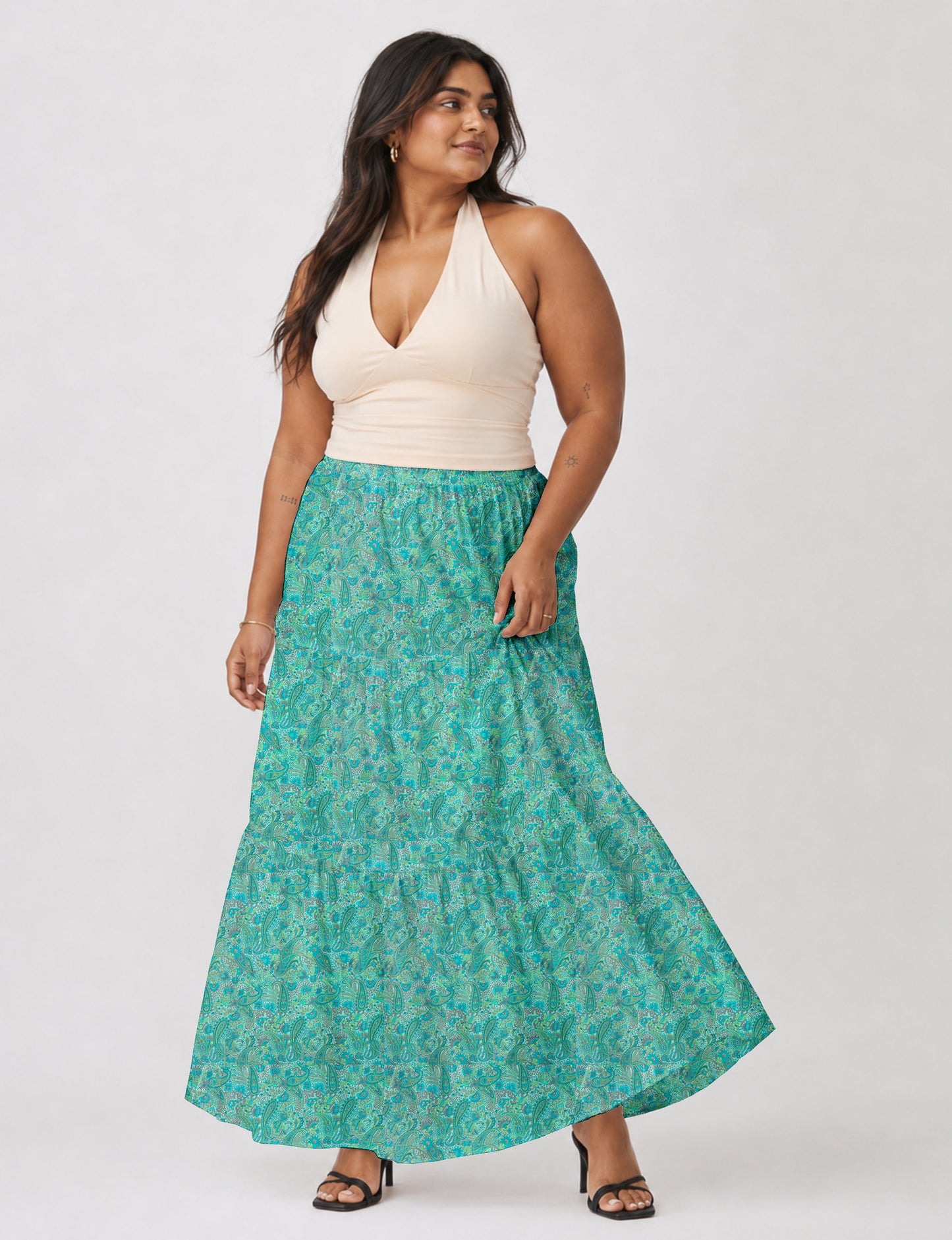 Woman wearing a yellow midi tiered skirt with a small geometric pattern, shown from the back, paired with beige top and