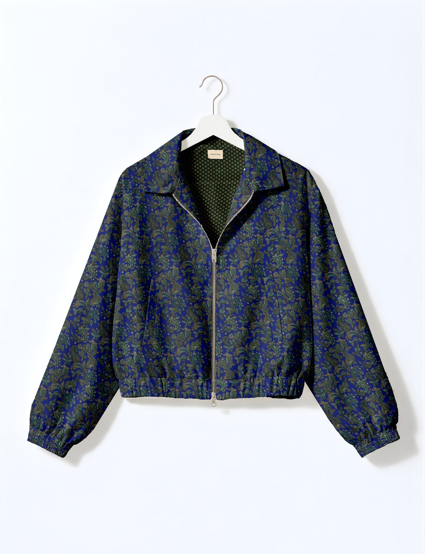 Women's cropped bomber jacket with twin metallic front zippers, welt pockets, elasticated hem and cuffs, and contrast sari print lining.