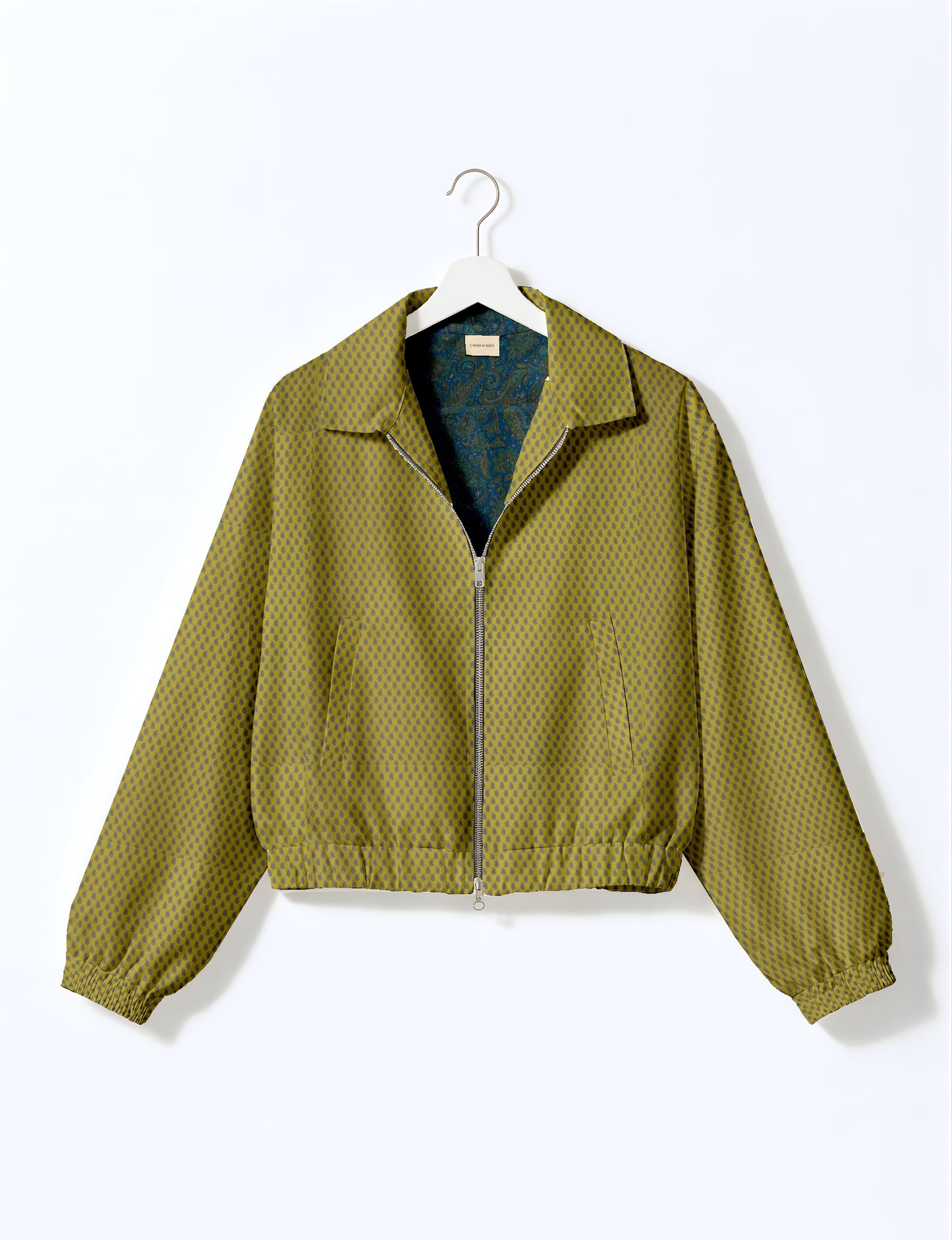 Women's cropped bomber jacket with twin metallic front zippers, welt pockets, elasticated hem and cuffs, and contrast sari print lining.