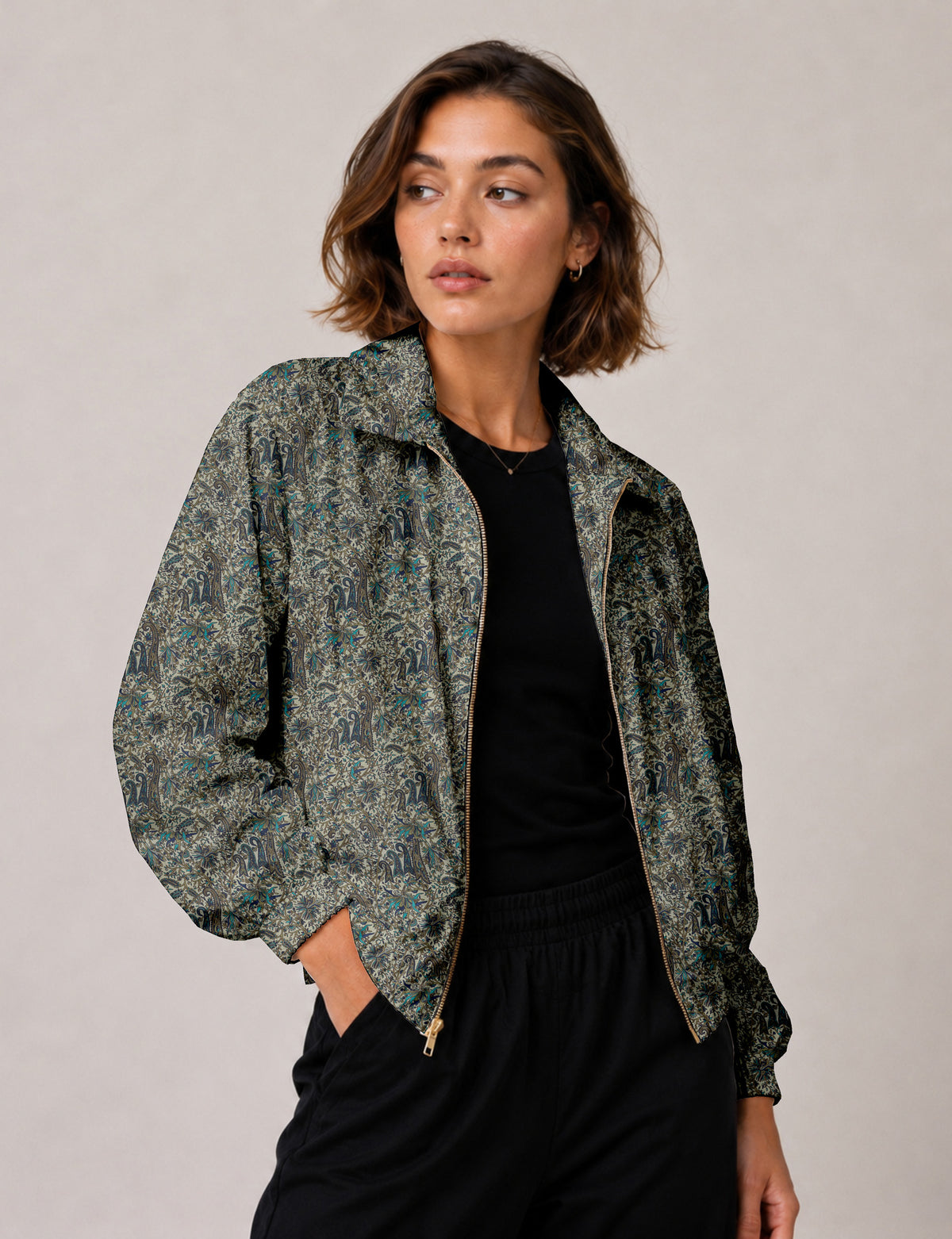 Woman wearing a yellow floral bomber jacket with front zipper, elastic cuffs, and side pockets, shown from front view