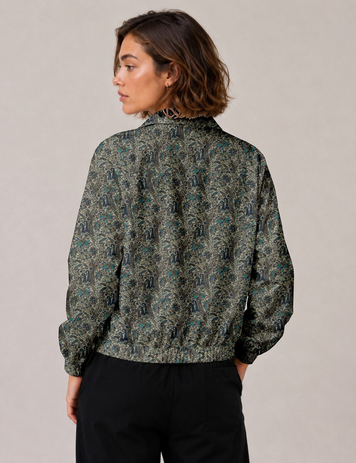 Brown floral bomber jacket with front zipper, elastic cuffs and hem, hanging on white hanger, red floral inner lining visible