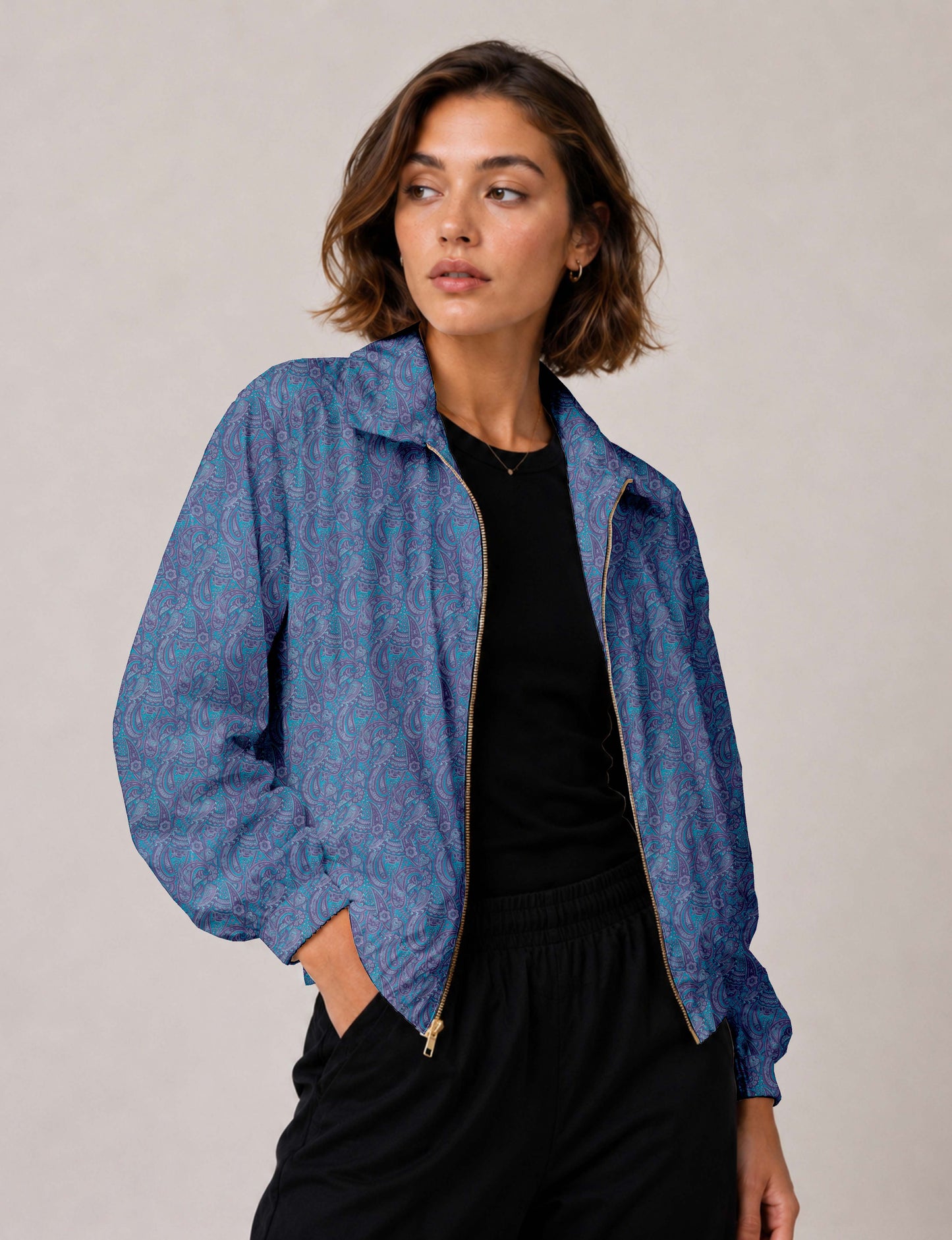 Brown floral bomber jacket with front zipper, elastic cuffs and hem, hanging on white hanger, red floral inner lining visible