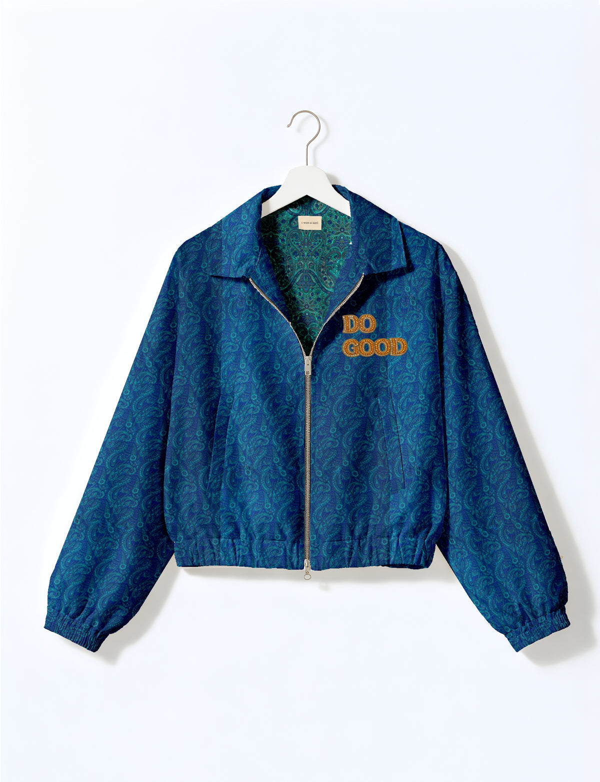 Gold cropped DO GOOD bomber jacket featuring hand-embroidered lettering on the left chest, contrasting inner lining and two functional pockets.