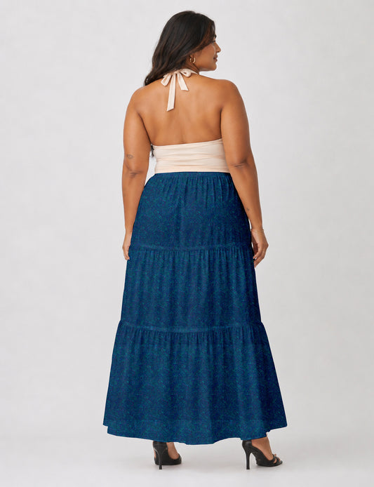 Woman wearing a yellow midi tiered skirt with a small geometric pattern, paired with a beige strapless top and white heels