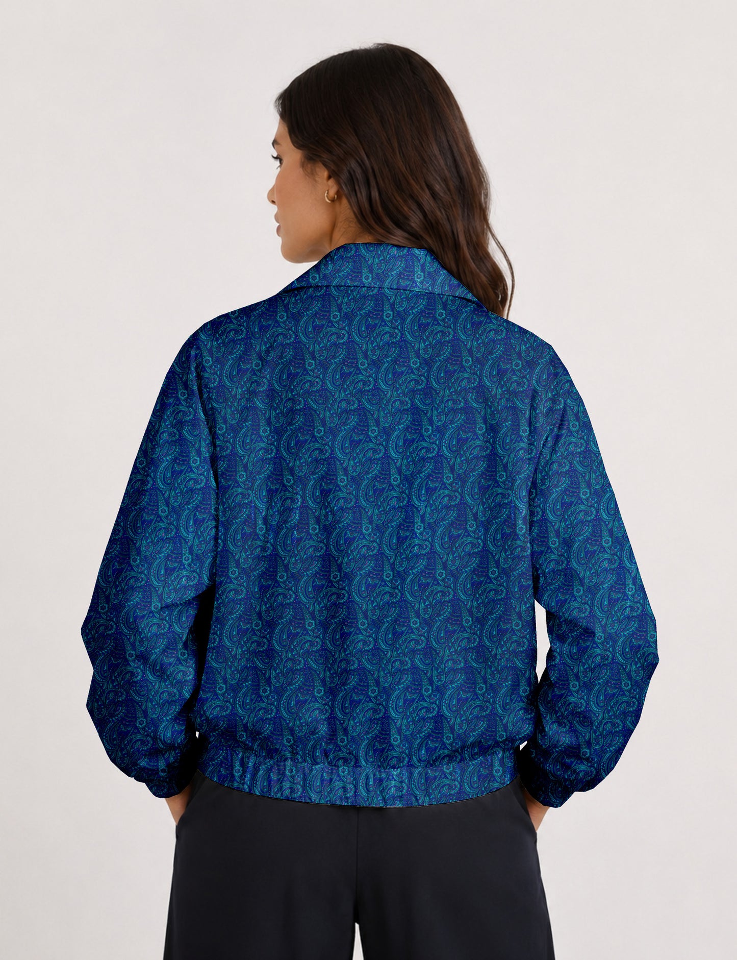 Brown floral bomber jacket with front zipper, elastic cuffs and hem, hanging on white hanger, red floral inner lining visible