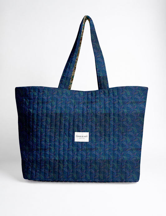 Quilted yellow tropical patterned beach bag with long handles and white label reading "I was a sari" front view