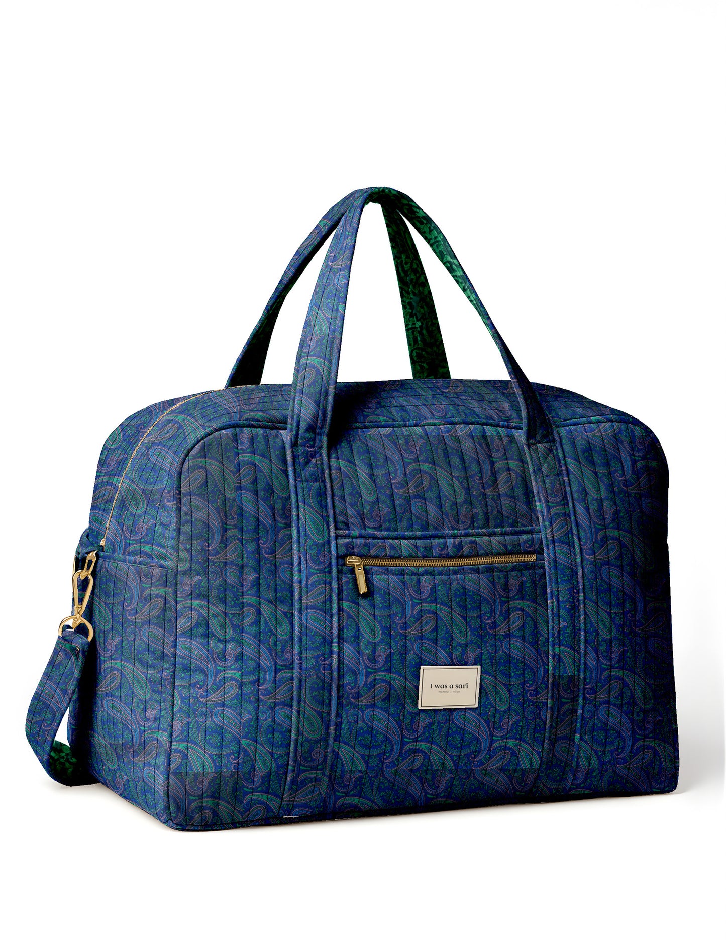 Brown quilted duffle bag with paisley pattern, front zip pocket, dual handles, and label reading "I was a sari"