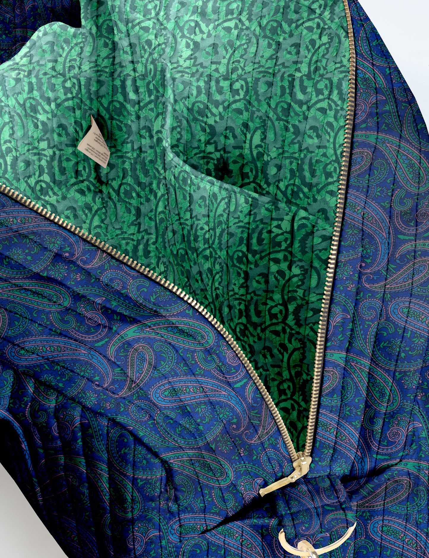 Brown quilted duffle bag with paisley pattern, front zip pocket, dual handles, and label reading "I was a sari"