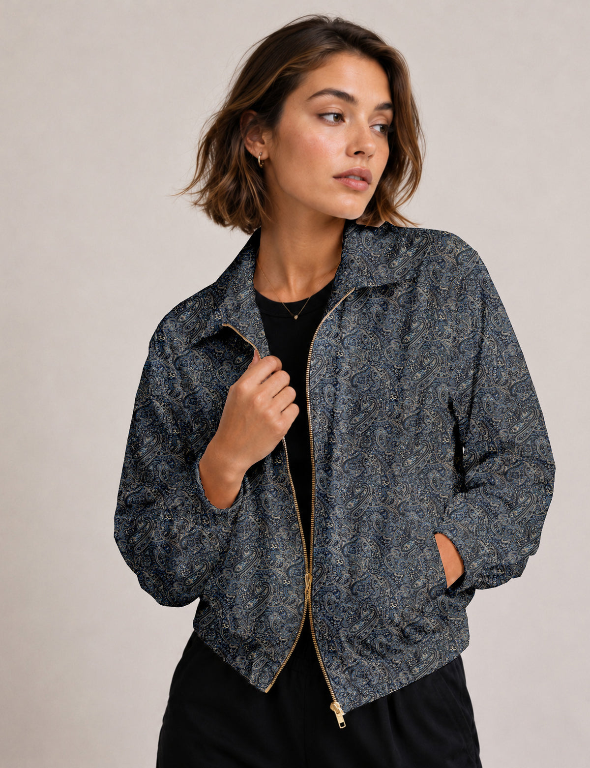 Brown floral bomber jacket with front zipper, elastic cuffs and hem, hanging on white hanger, red floral inner lining visible