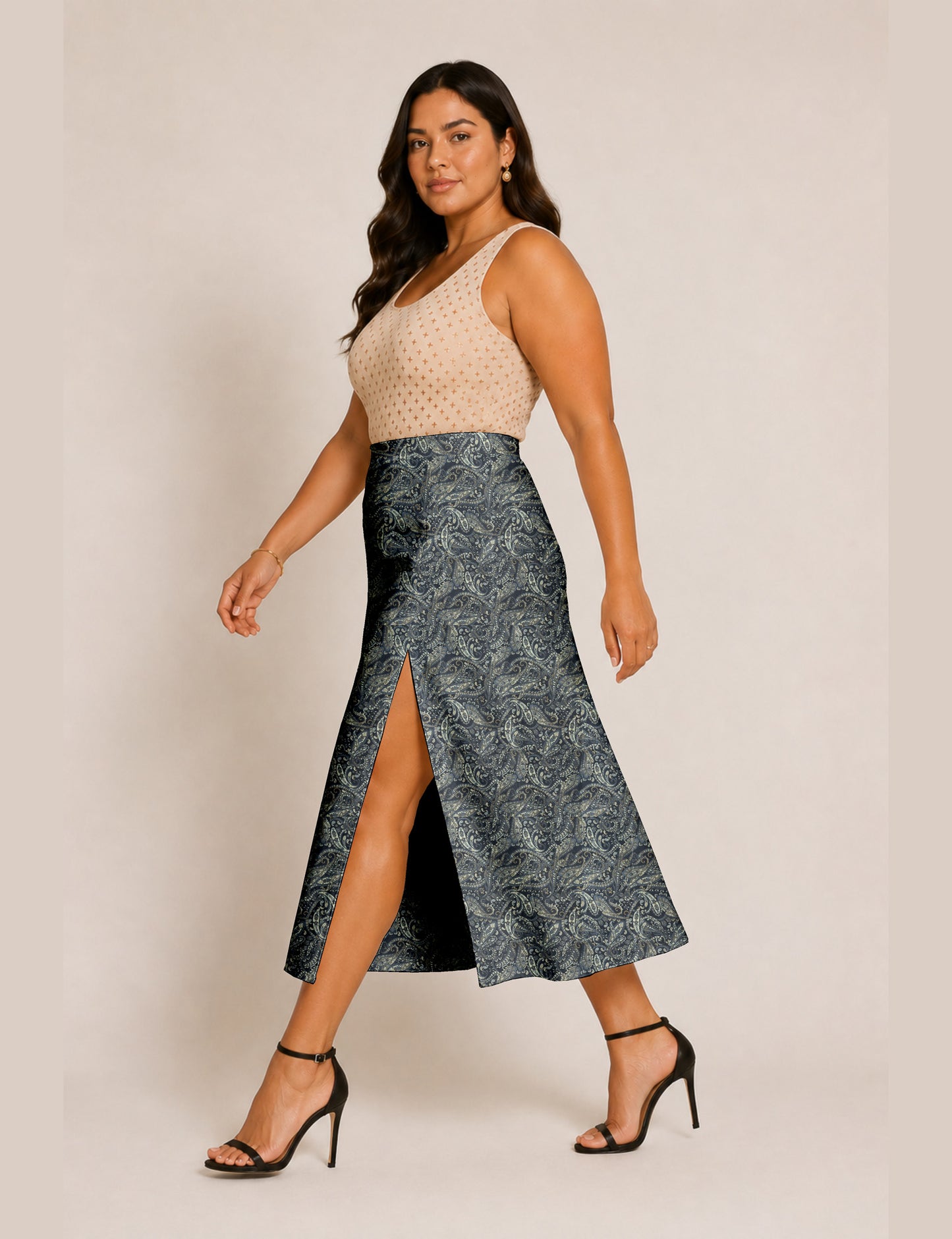 Woman wearing a yellow and black micro patterned A-line skirt with front slit, paired with beige sleeveless top and black