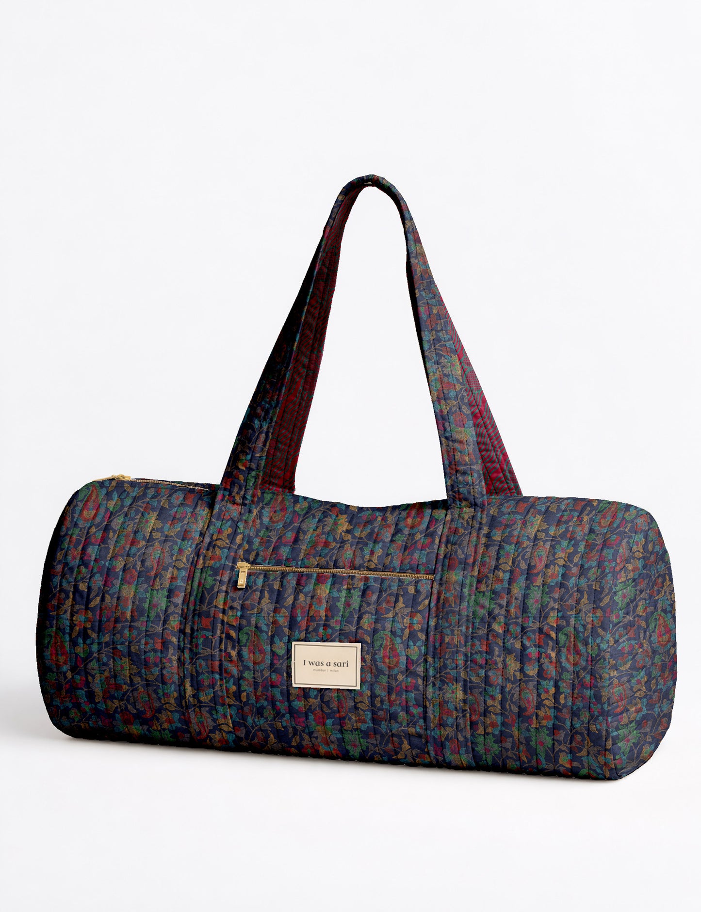 Brown paisley quilted bowling bag with dual handles, front zipper pocket, and "I was a sari" label on front side