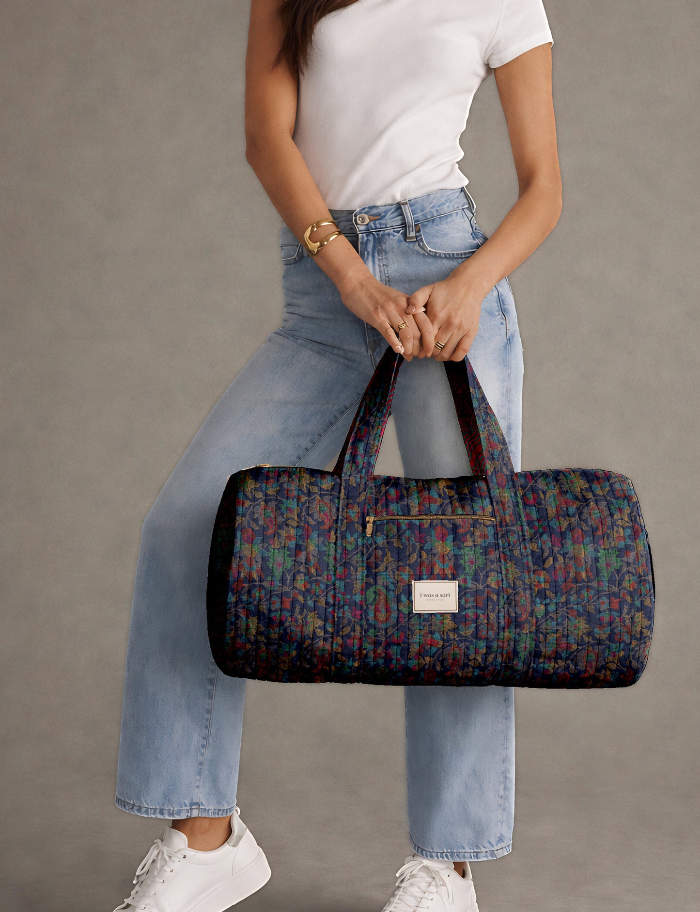 Brown paisley quilted bowling bag with dual handles, front zipper pocket, and "I was a sari" label on front side