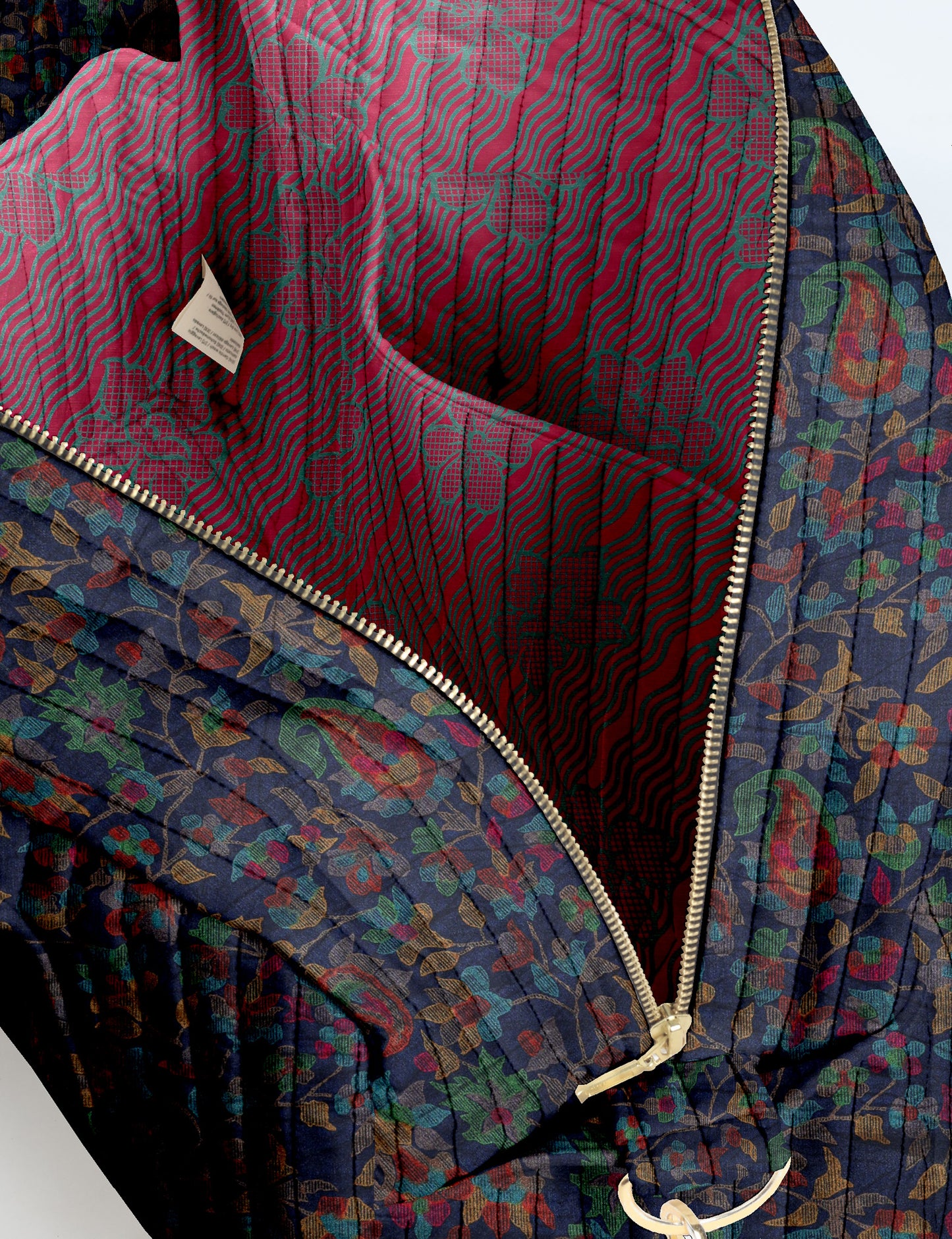 Brown quilted duffle bag with paisley pattern, front zip pocket, dual handles, and label reading "I was a sari"