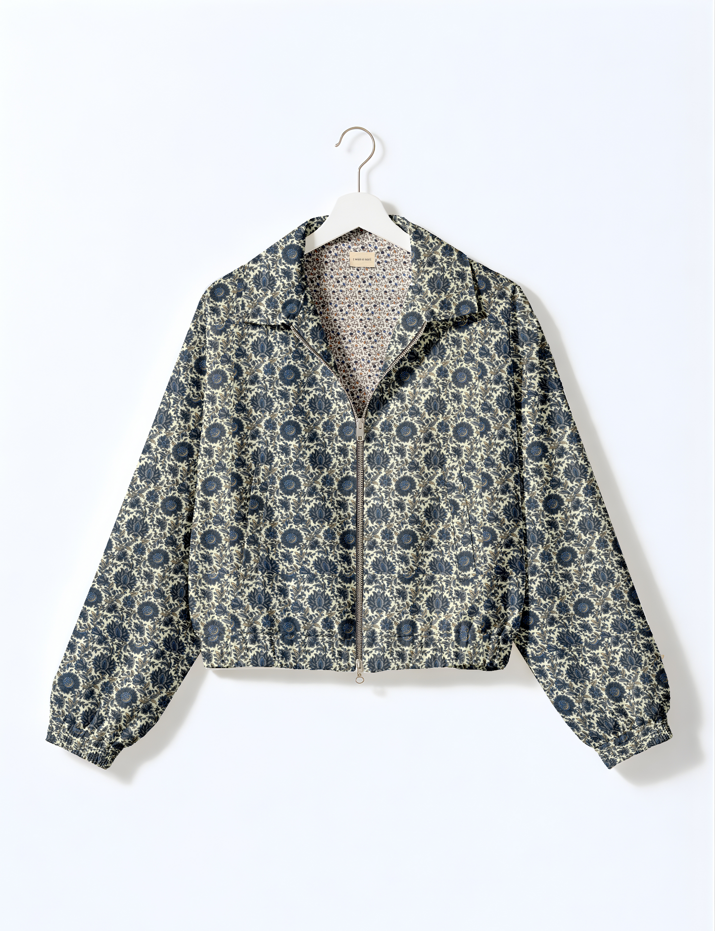 Women's cropped bomber jacket with twin metallic front zippers, welt pockets, elasticated hem and cuffs, and contrast sari print lining.