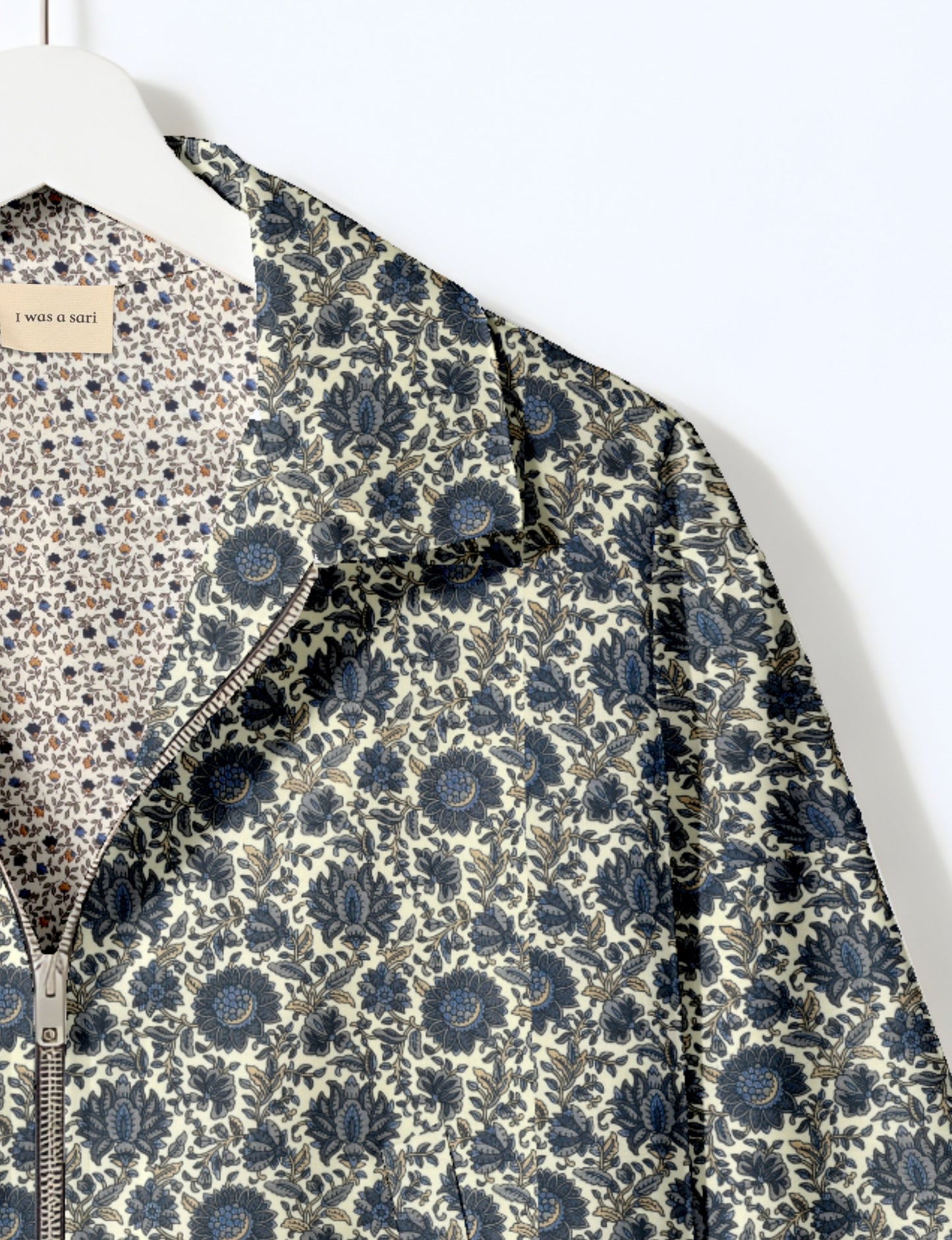 Women's cropped bomber jacket with twin metallic front zippers, welt pockets, elasticated hem and cuffs, and contrast sari print lining.