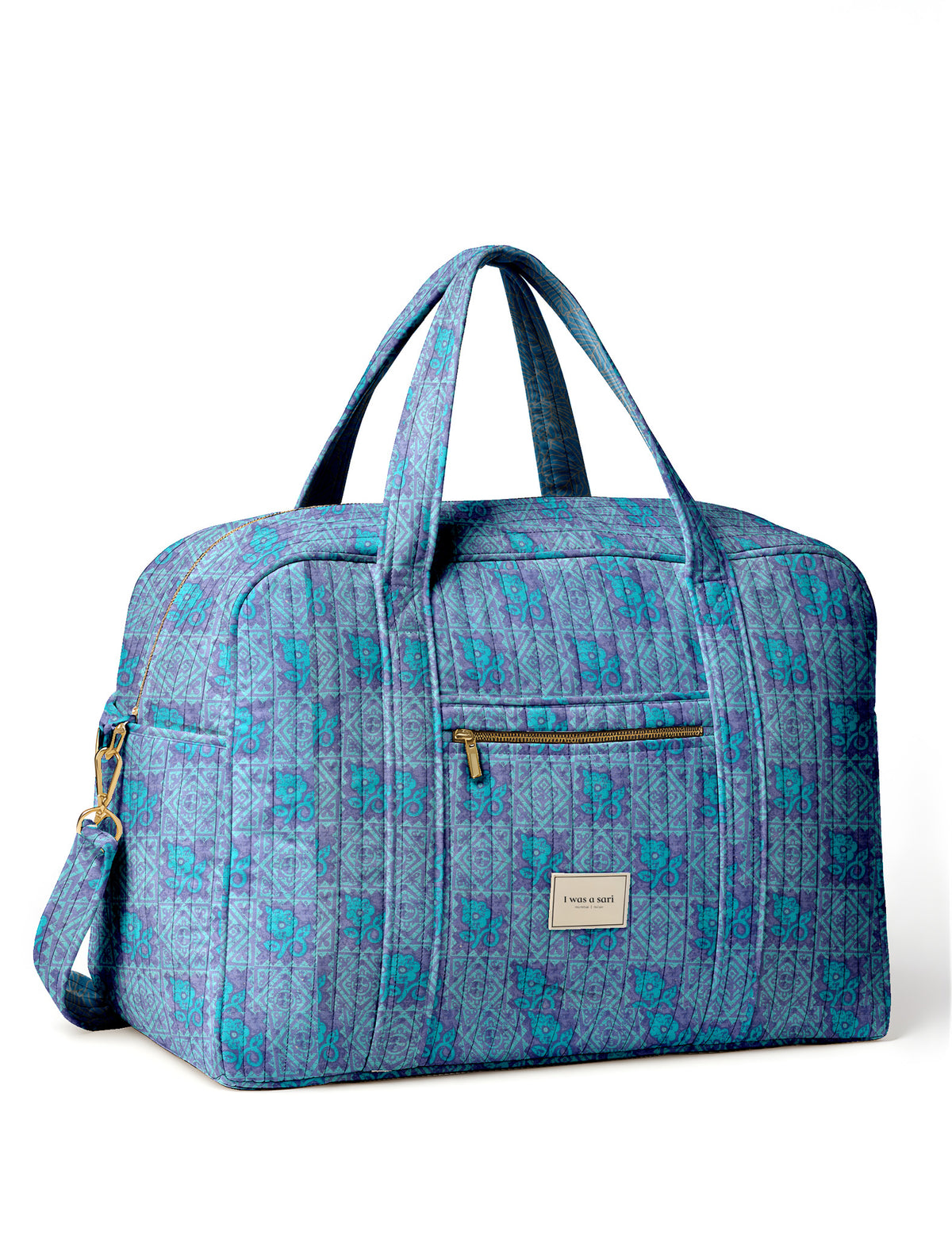 Brown quilted duffle bag with paisley pattern, front zip pocket, dual handles, and label reading "I was a sari"
