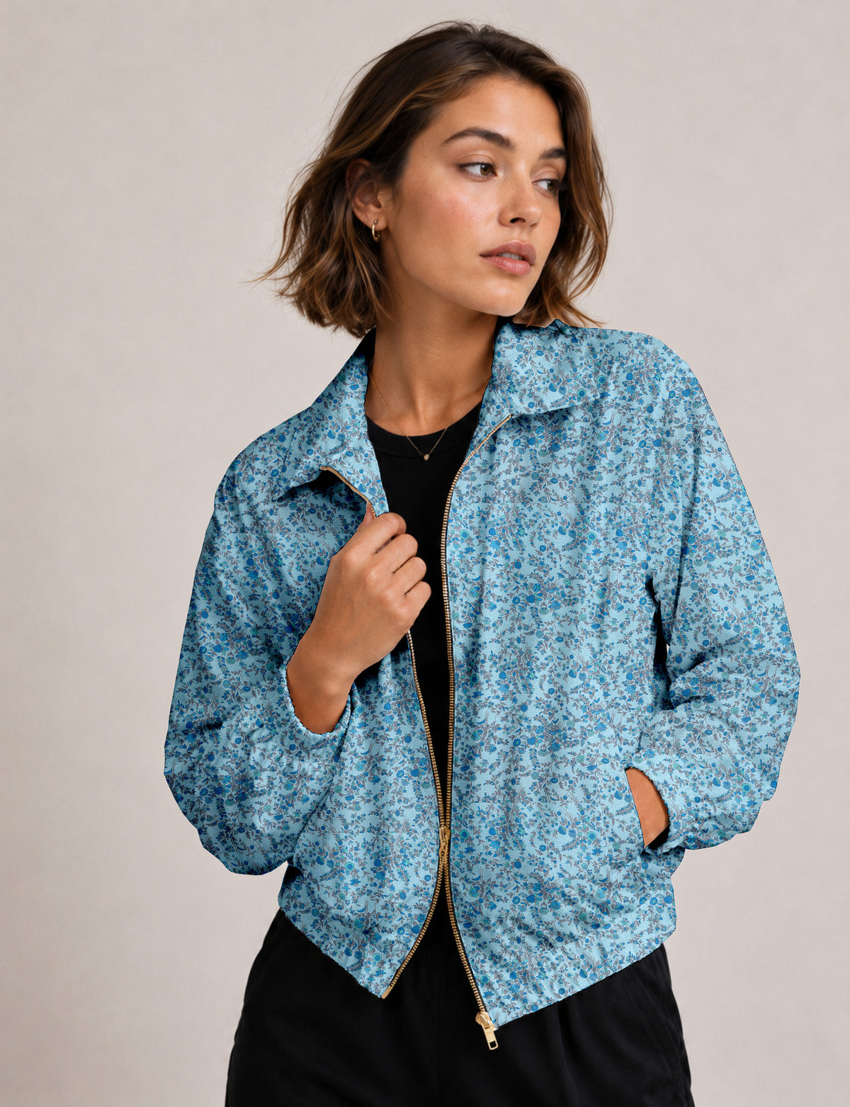 Woman wearing a yellow floral bomber jacket with front zipper, elastic cuffs, and side pockets, shown from front view
