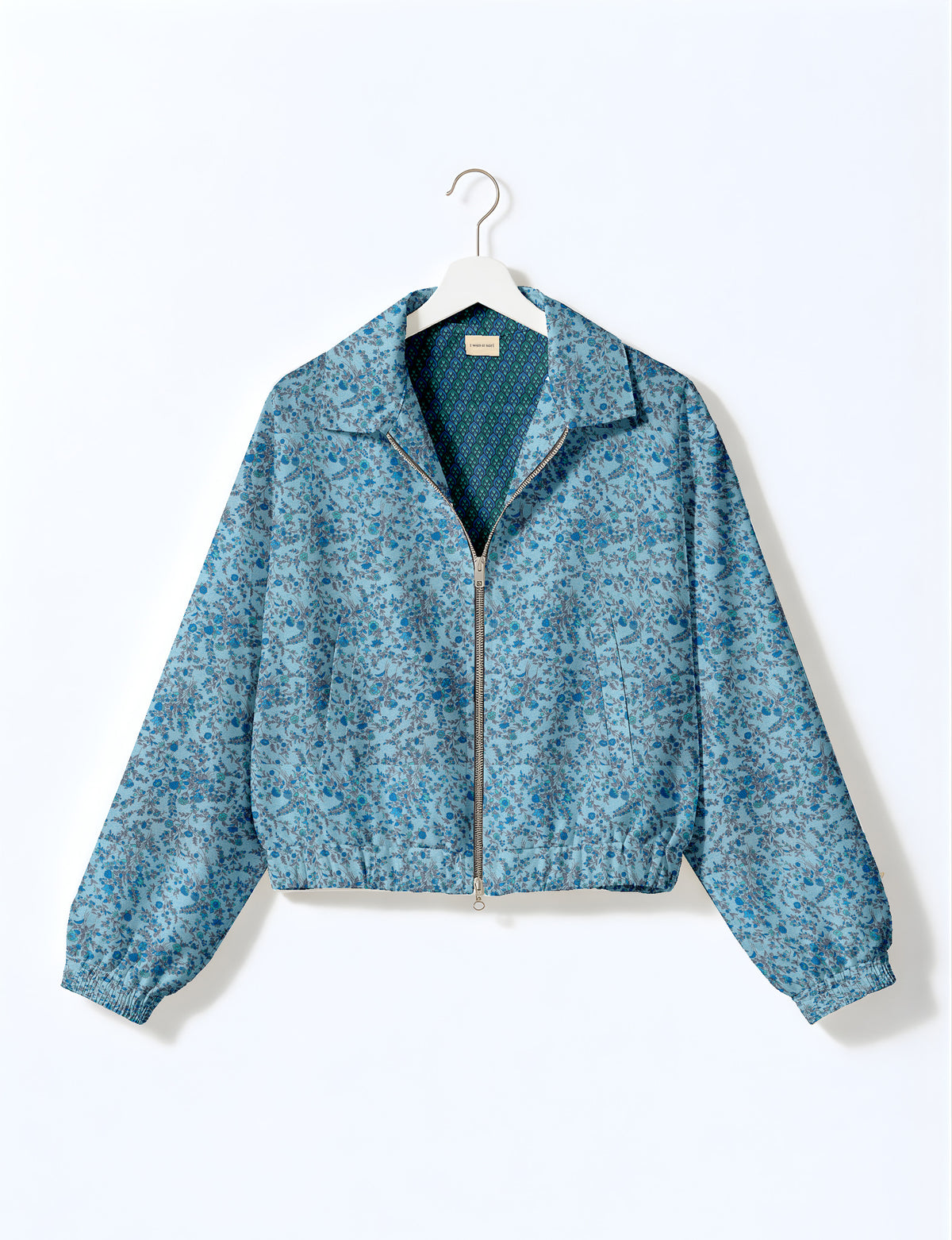 Brown floral bomber jacket with front zipper, elastic cuffs and hem, hanging on white hanger, red floral inner lining visible
