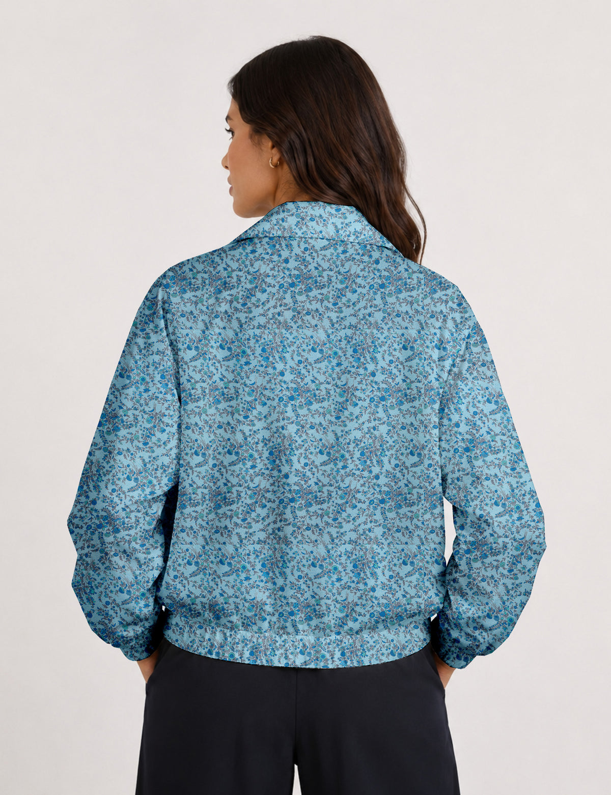 Woman wearing a yellow floral bomber jacket with front zipper, elastic cuffs, and side pockets, shown from front view