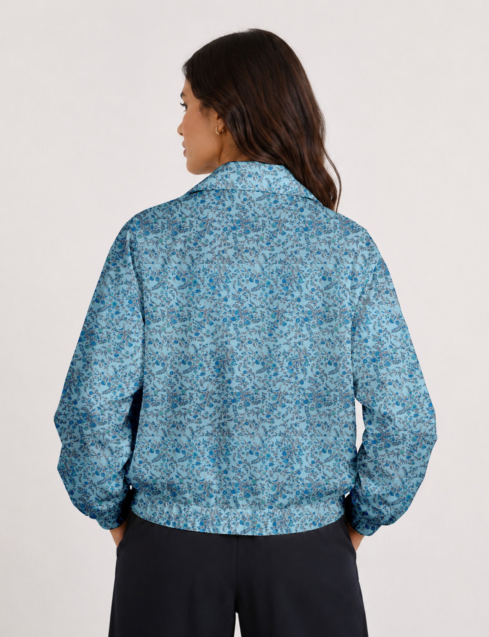 Woman wearing a yellow floral bomber jacket with front zipper, elastic cuffs, and side pockets, shown from front view
