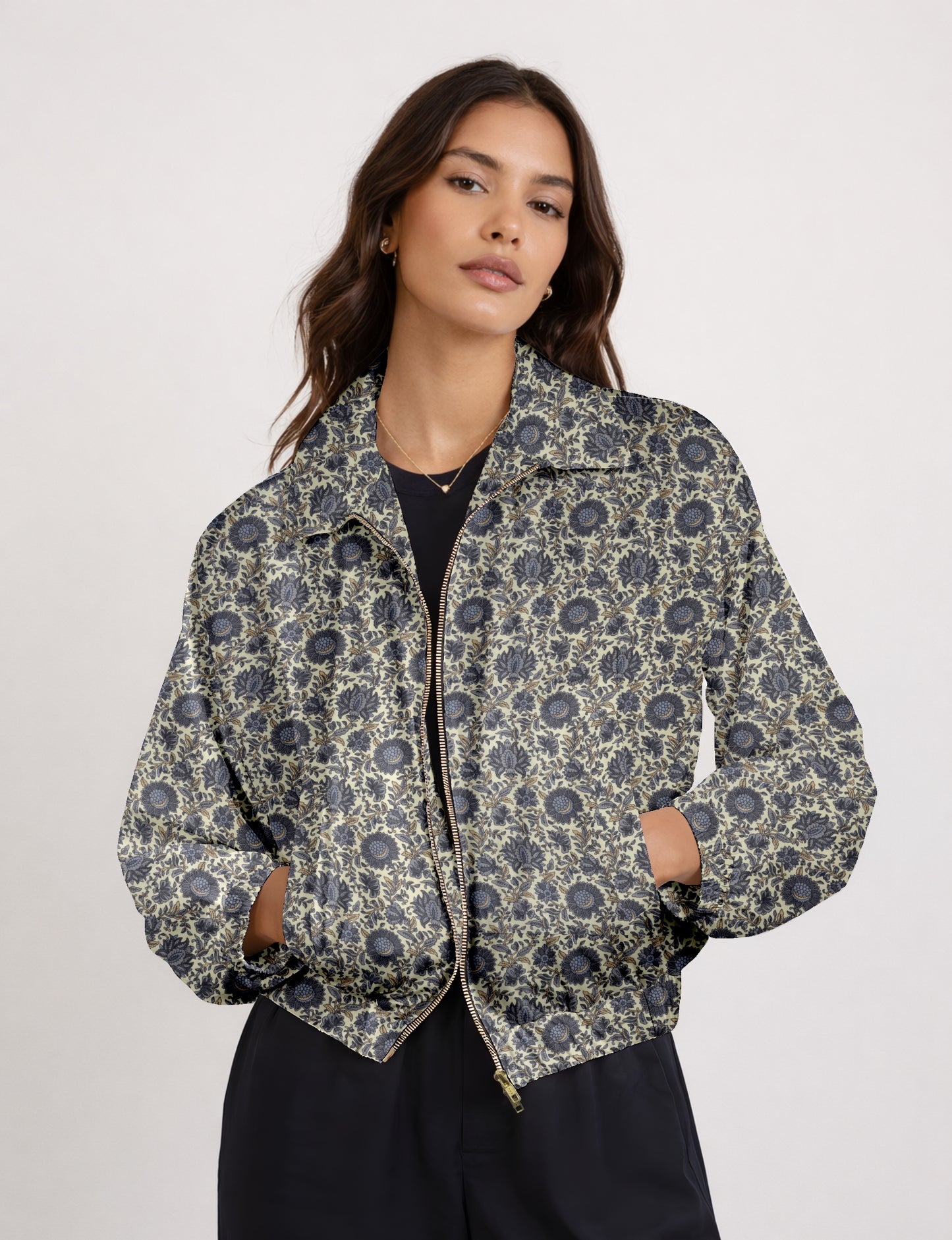 Woman wearing a yellow bomber jacket with a micro geometric pattern, front zipper, and side pockets, paired with black pants