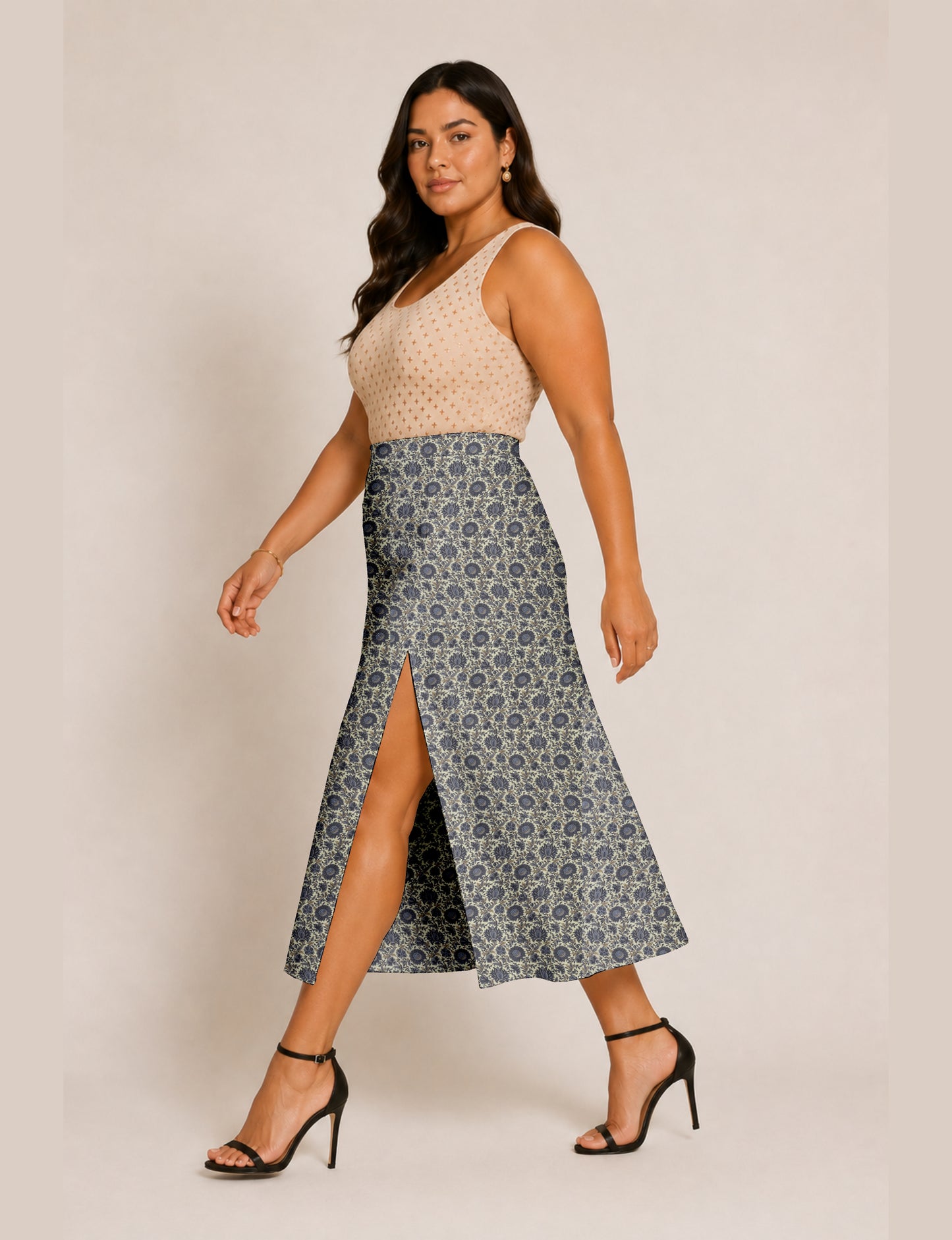 Woman wearing a yellow and black micro patterned A-line skirt with front slit, paired with beige sleeveless top and black