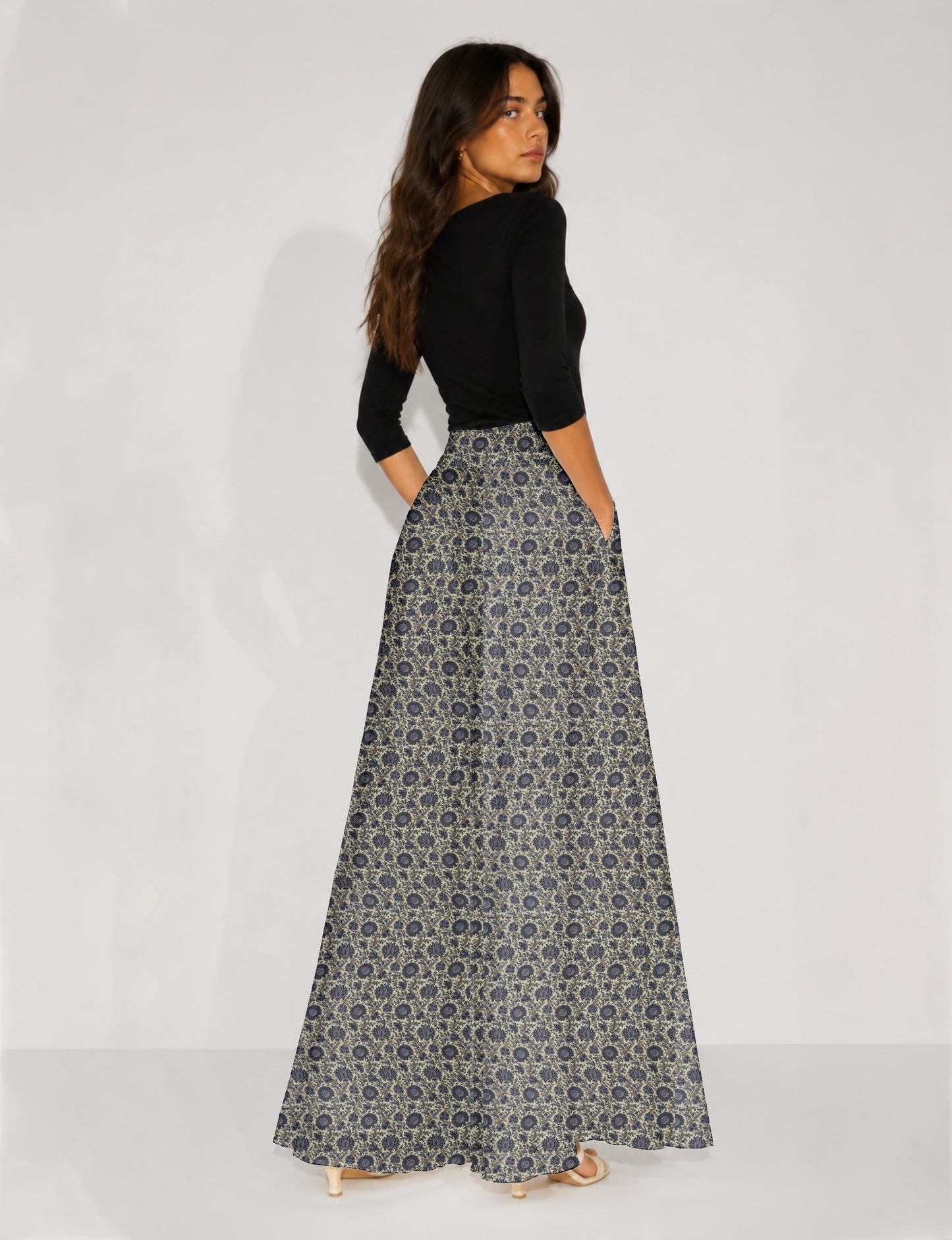 Woman wearing blue wide leg palazzo trousers with black and brown floral print, paired with brown sleeveless top and white