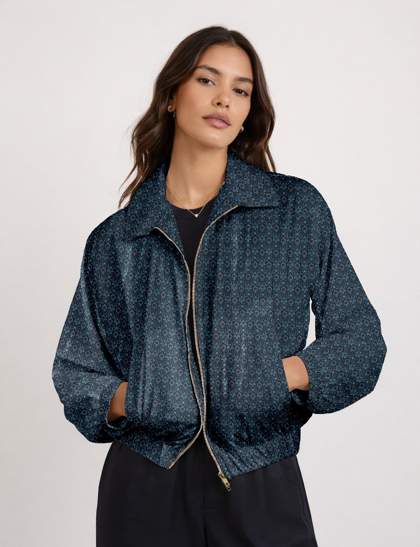 Woman wearing a yellow bomber jacket with a micro geometric pattern, front zipper, and side pockets, paired with black pants
