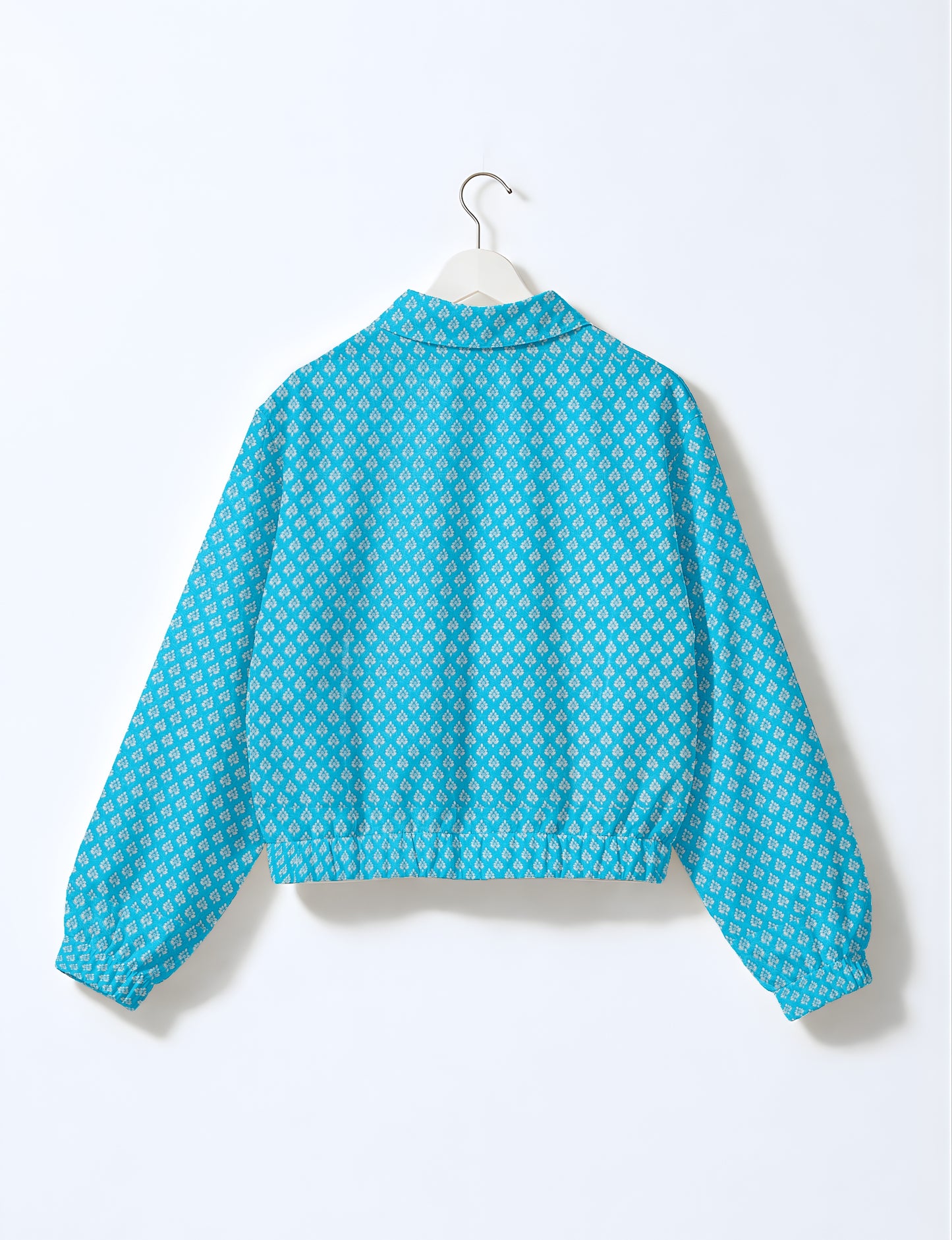 Yellow bomber jacket with micro diamond and floral pattern, elastic cuffs and waistband, shown from back on hanger