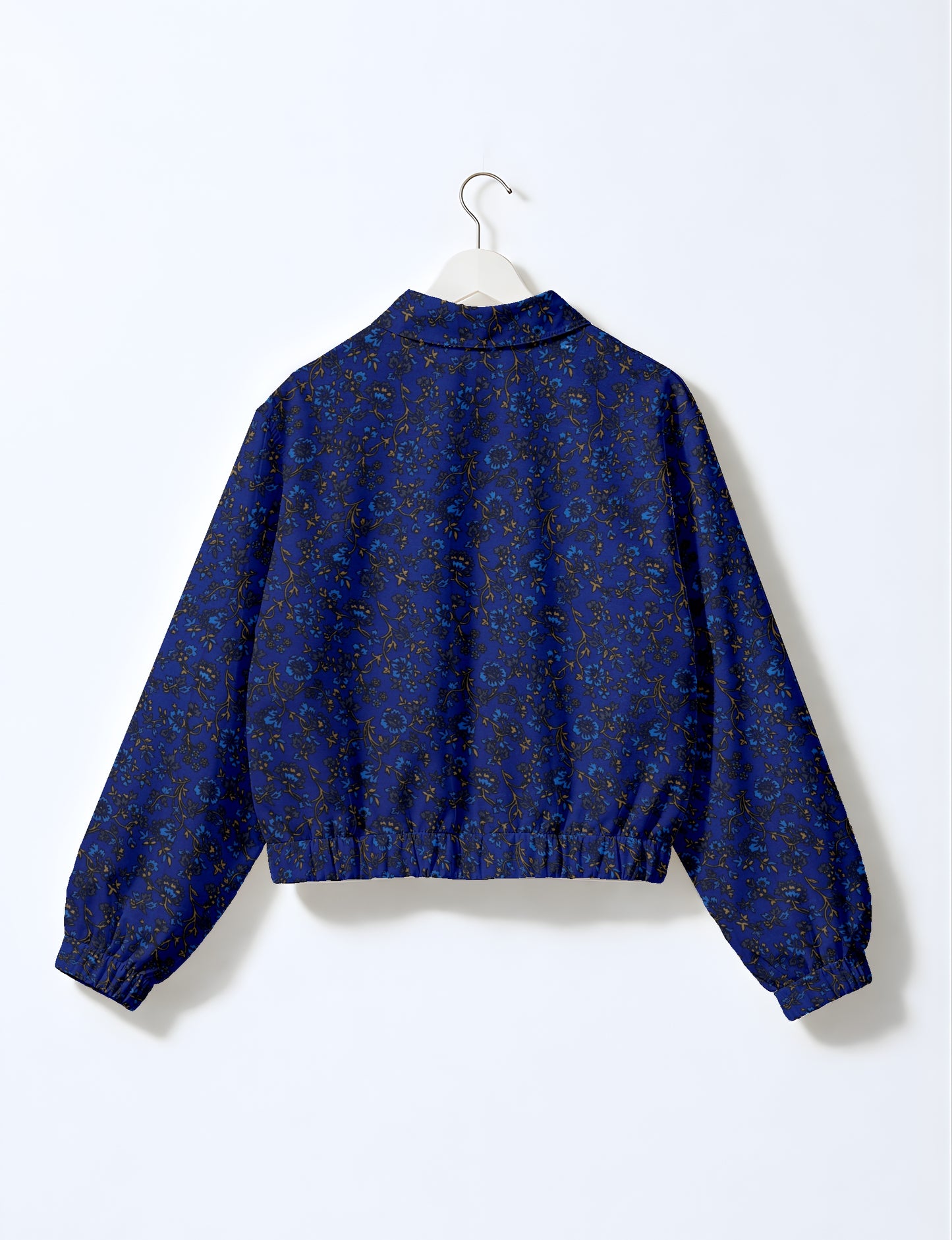 Blue bomber jacket with tropical floral pattern, elastic cuffs and waistband, shown from back on white hanger