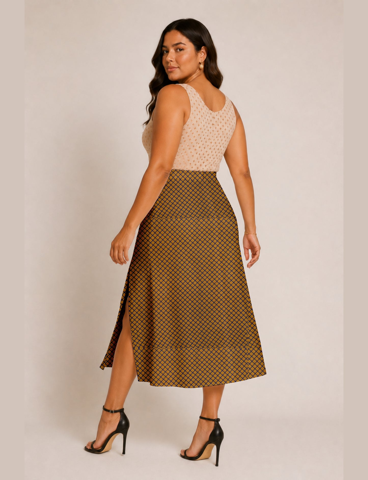 Woman wearing a yellow micro design A-line skirt with side slit, paired with a sleeveless beige top with small cross